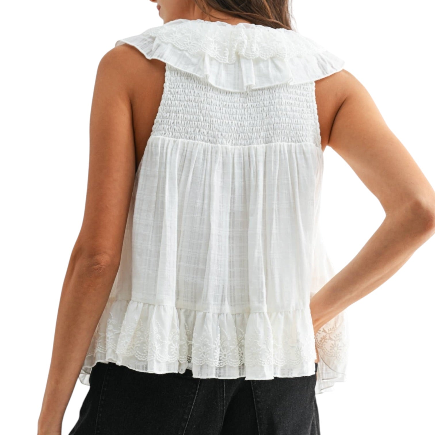 Ivory sleeveless top with ruffled details on a white background