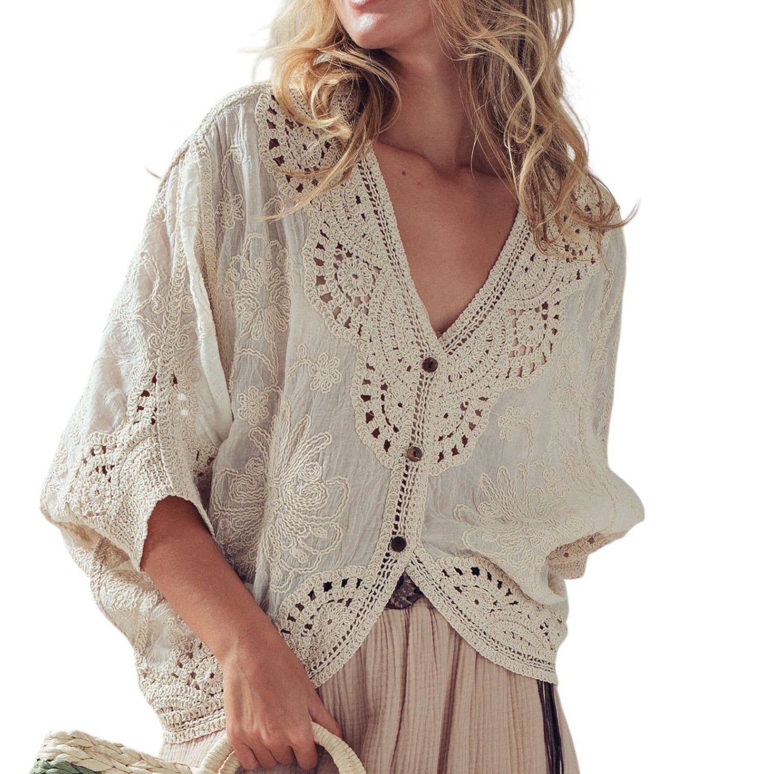 Woman wearing a beige crochet cardigan on a white background