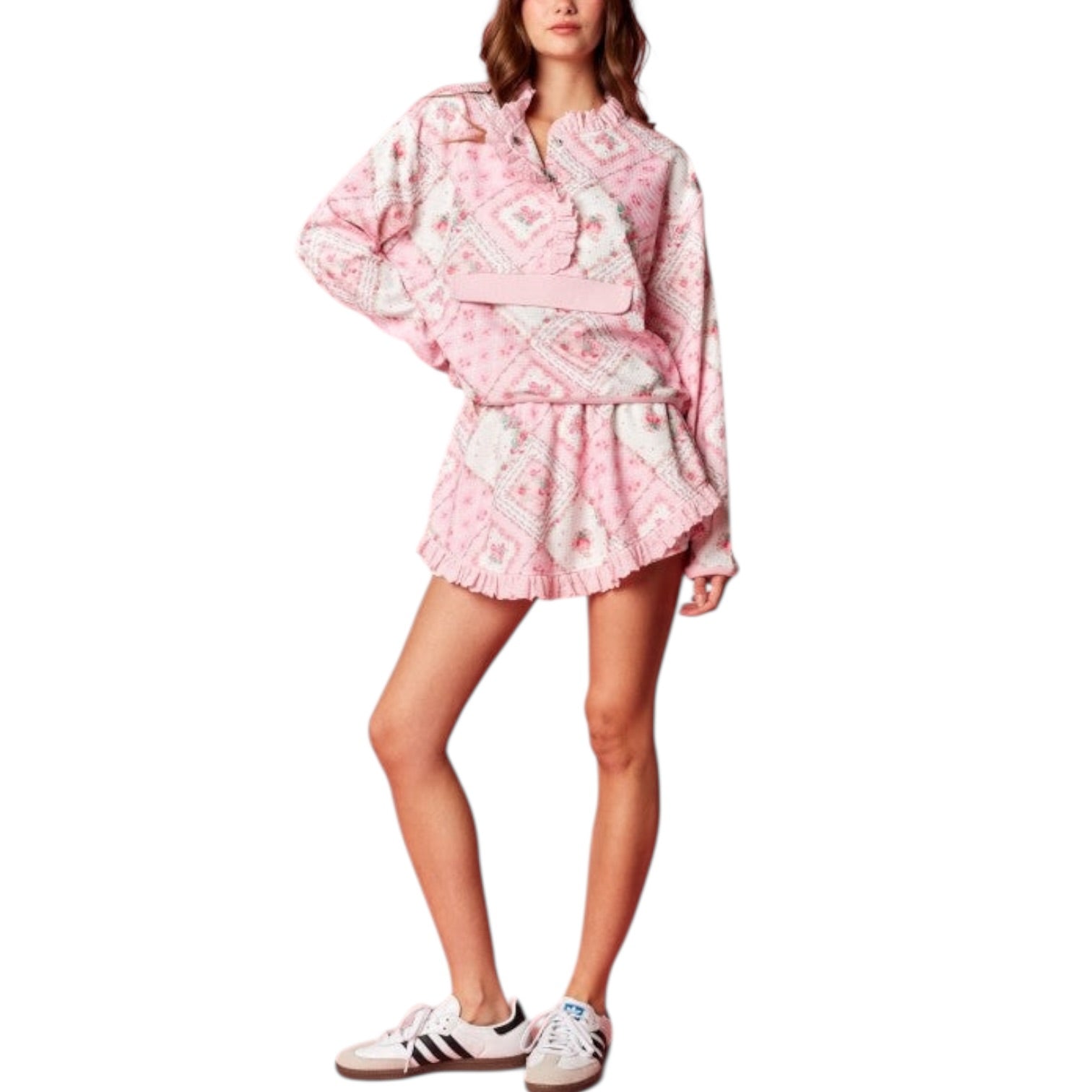 Woman wearing a pink and white patterned outfit with sneakers on a white background