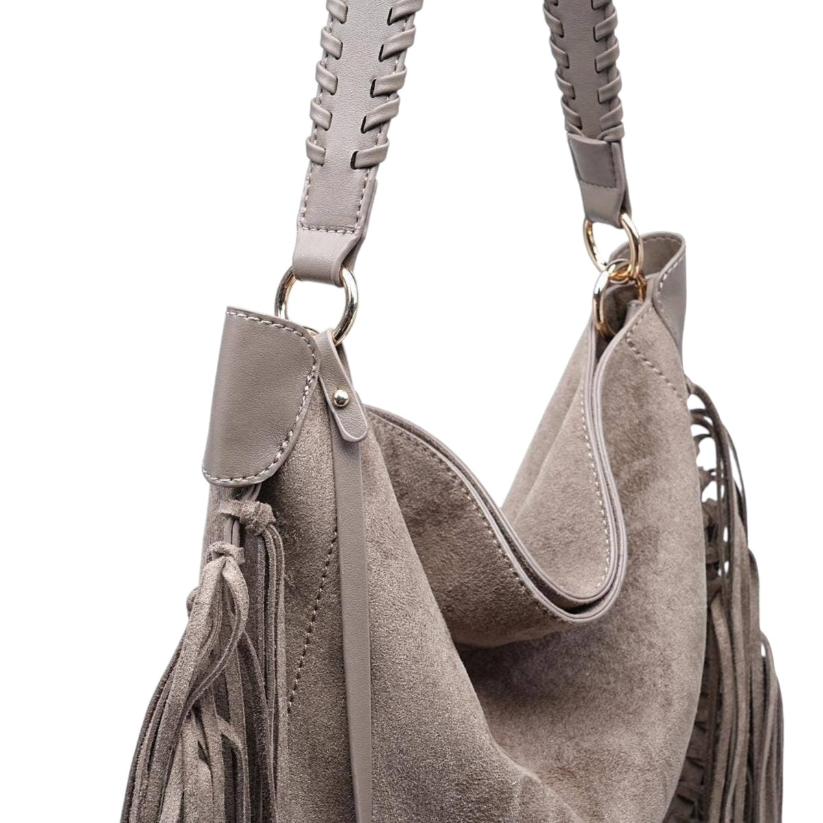 A taupe suede slouchy shoulder bag with braided leather shoulder straps, gold-tone hardware, and fringe tassels, shown against a plain white background.