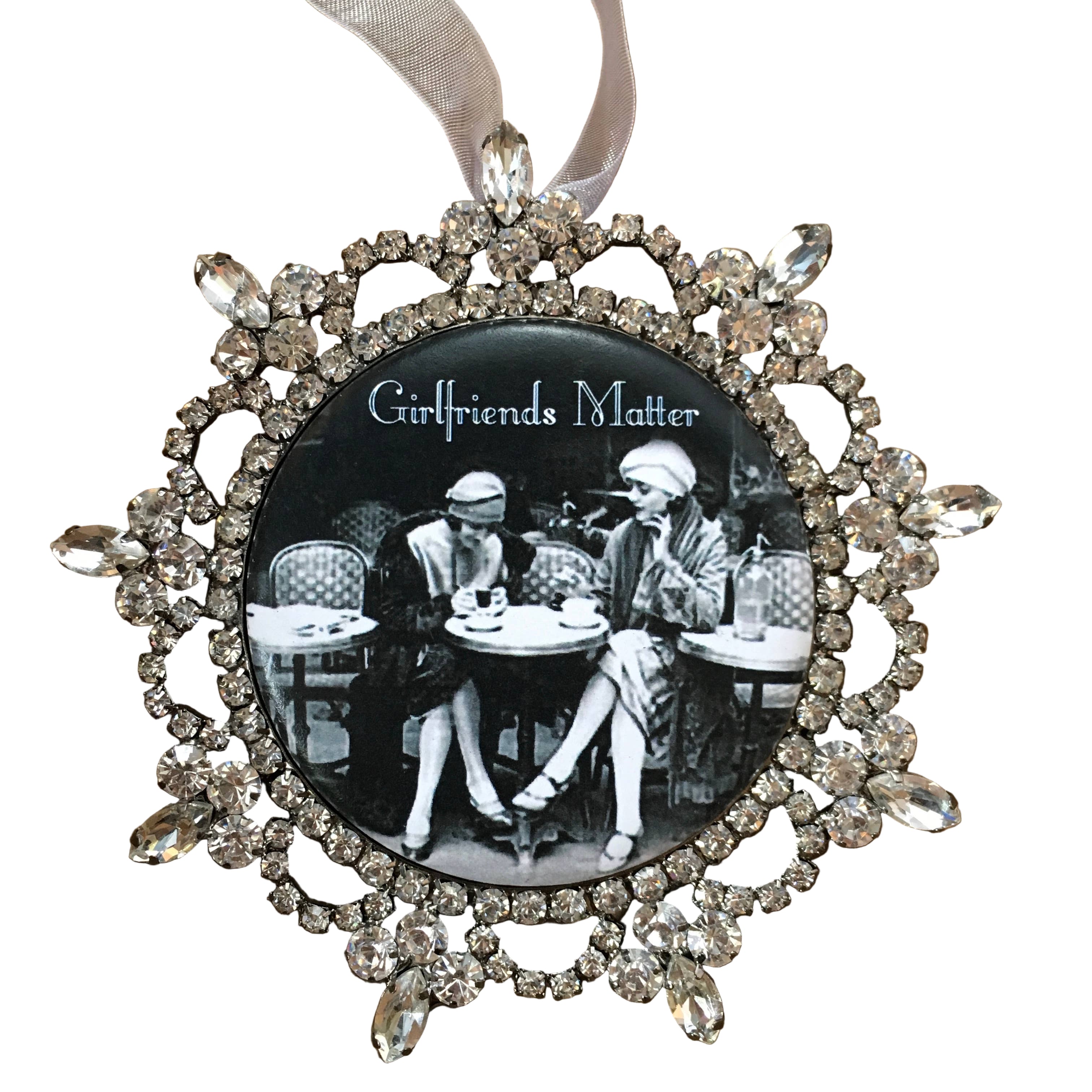 Decorative ornament with rhinestones and a black and white photo of two people at a table, with 'Girlfriends Matter' text.