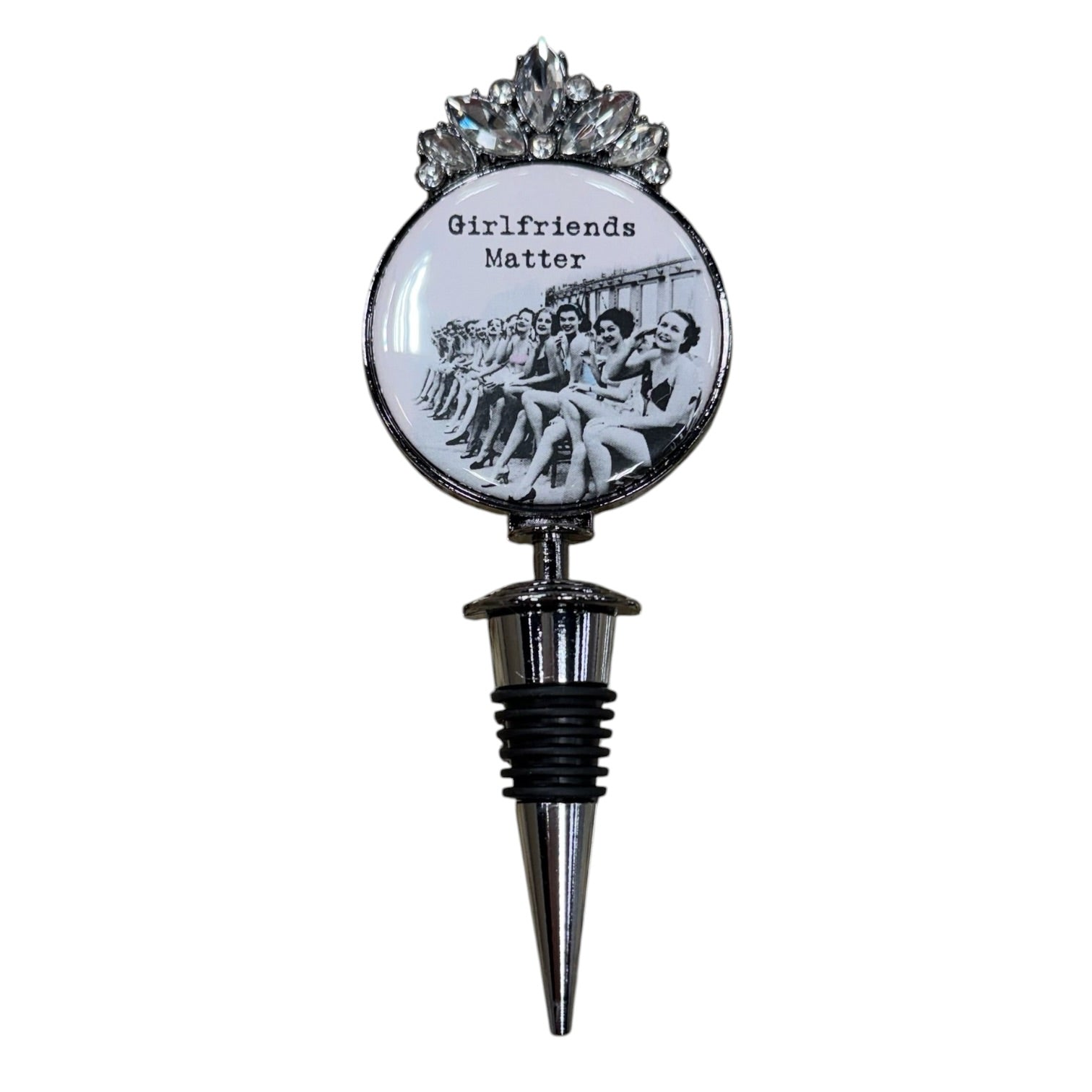 A novelty wine bottle stopper featuring a circular emblem with the text 'Girlfriends Matter' and a black-and-white photo of a group of women, topped with a silver floral crown and a metallic pointed stopper below.