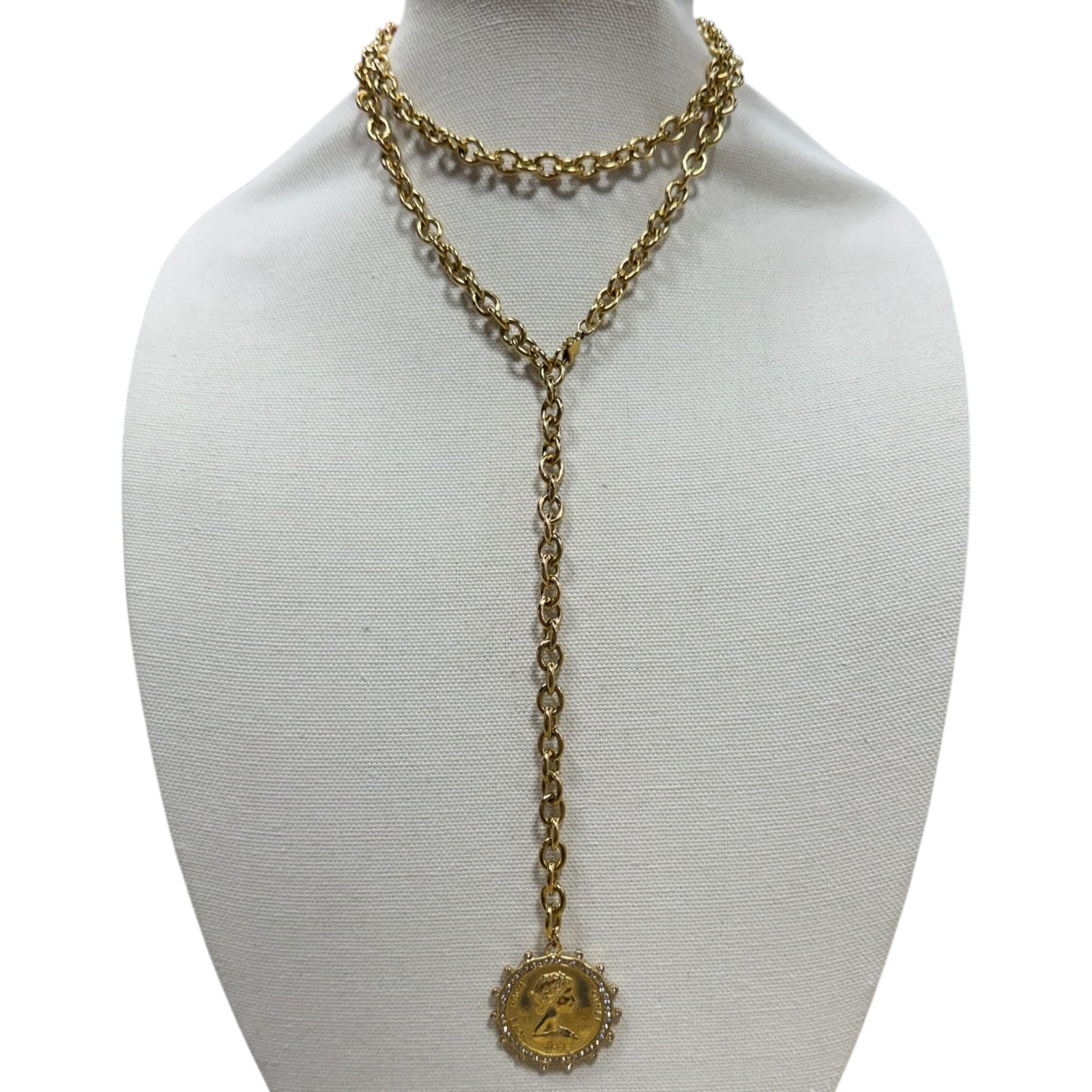 Gold chain necklace with a pendant on a mannequin bust against a white background