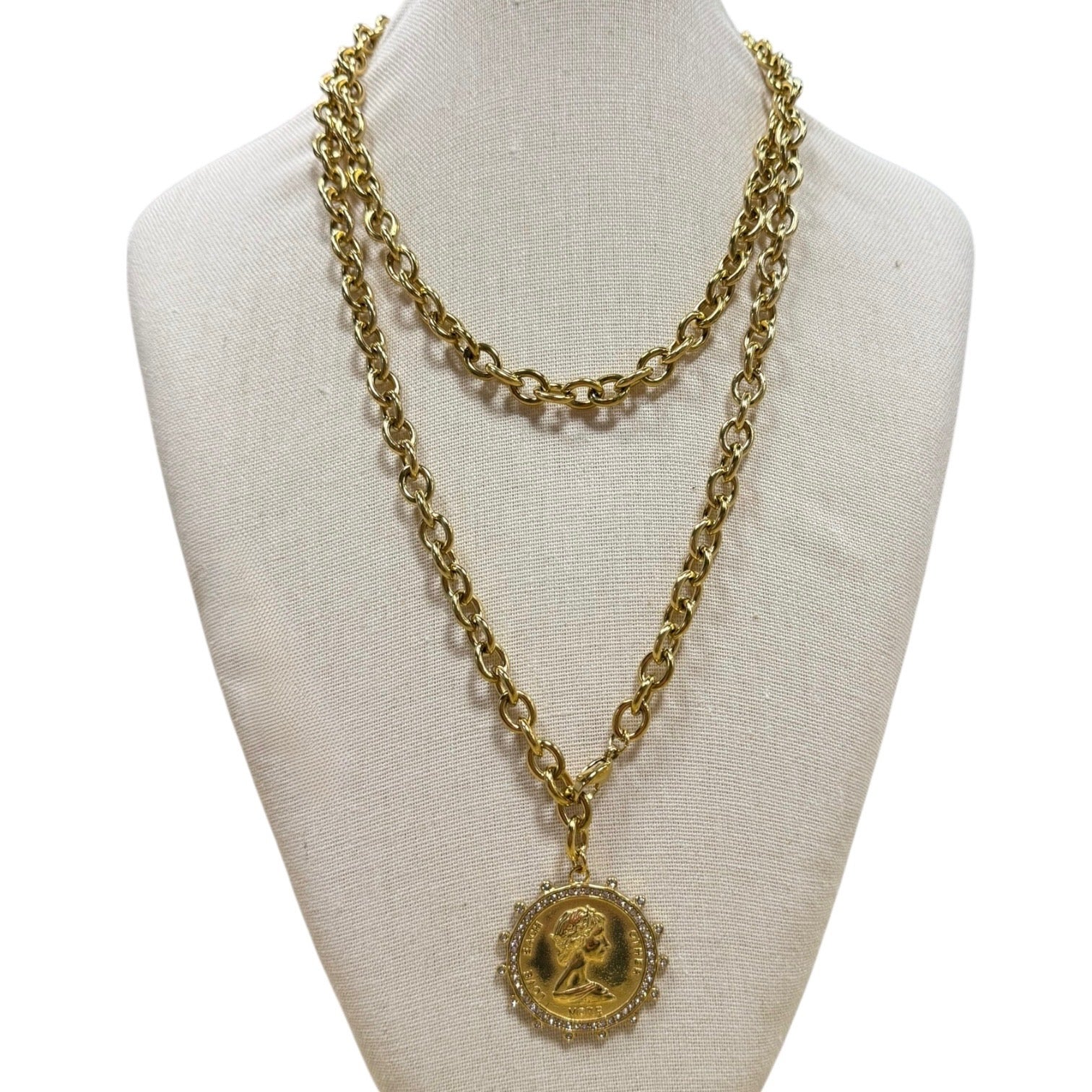 Gold chain necklace with a pendant on a mannequin bust.