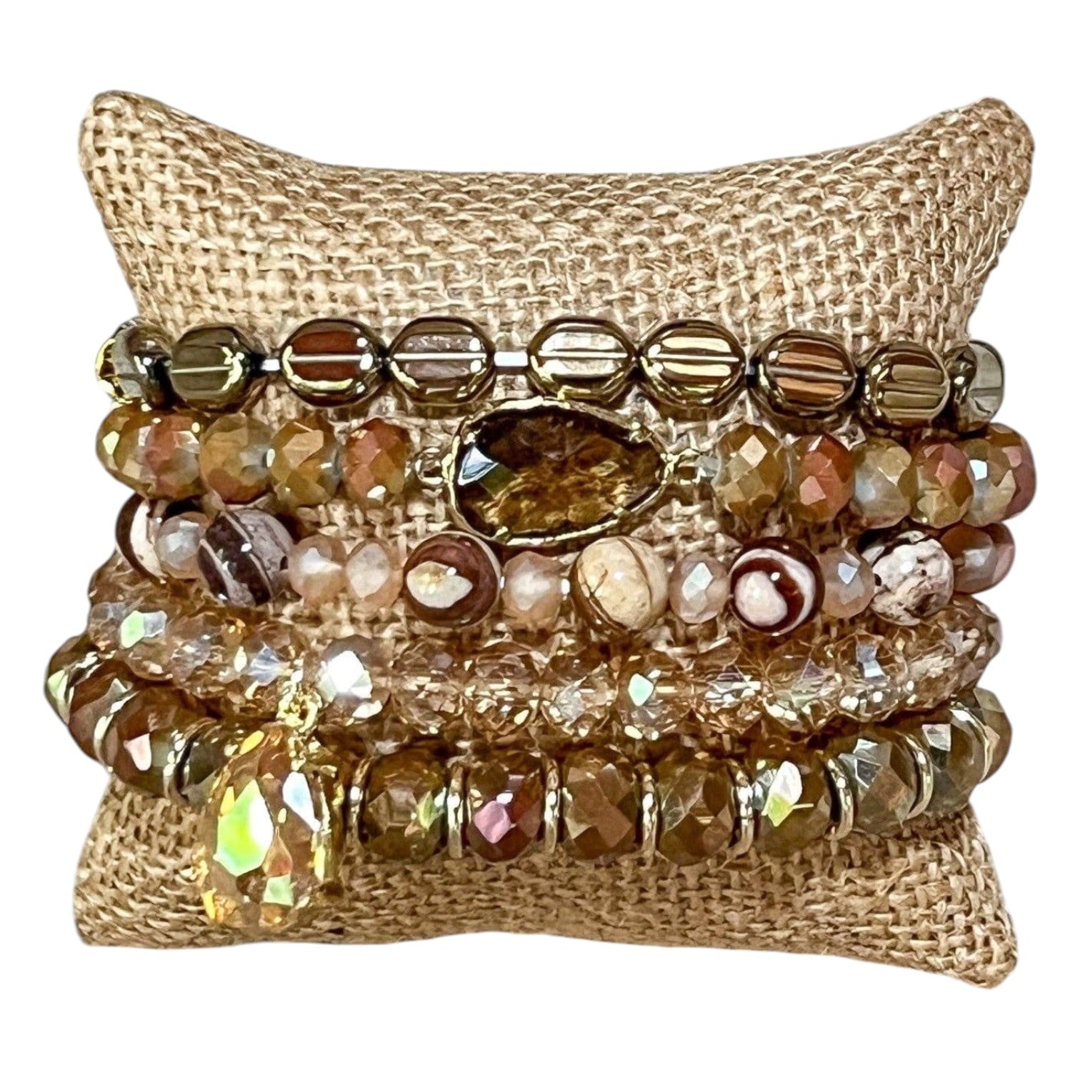 Stack of beaded bracelets on a textured beige pillow