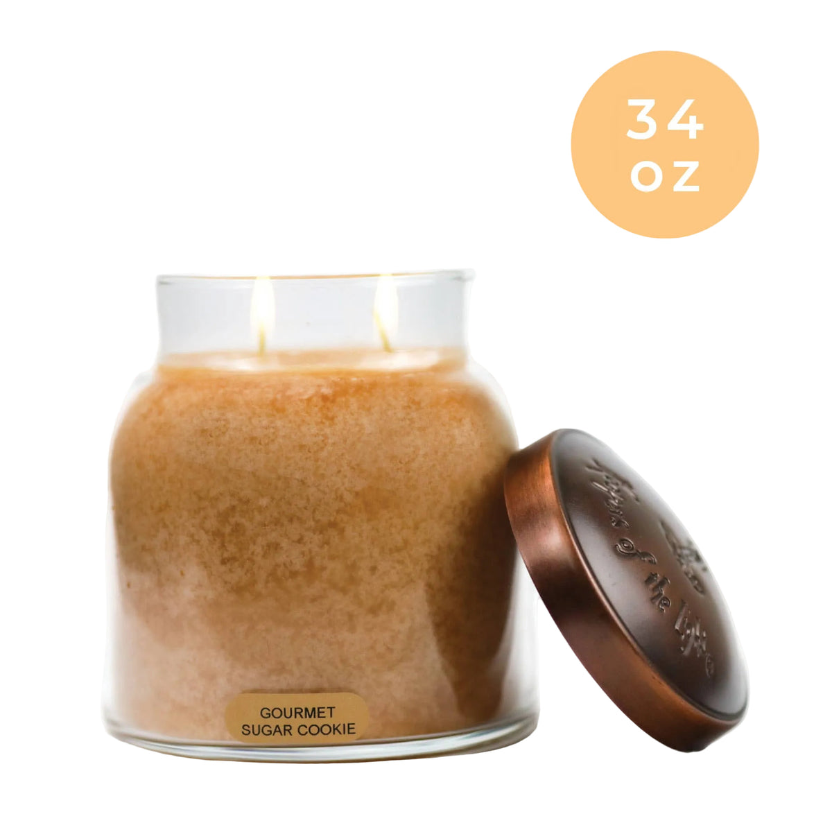 Gourmet sugar cookie-scented candle in a glass jar with a bronze lid on a white background