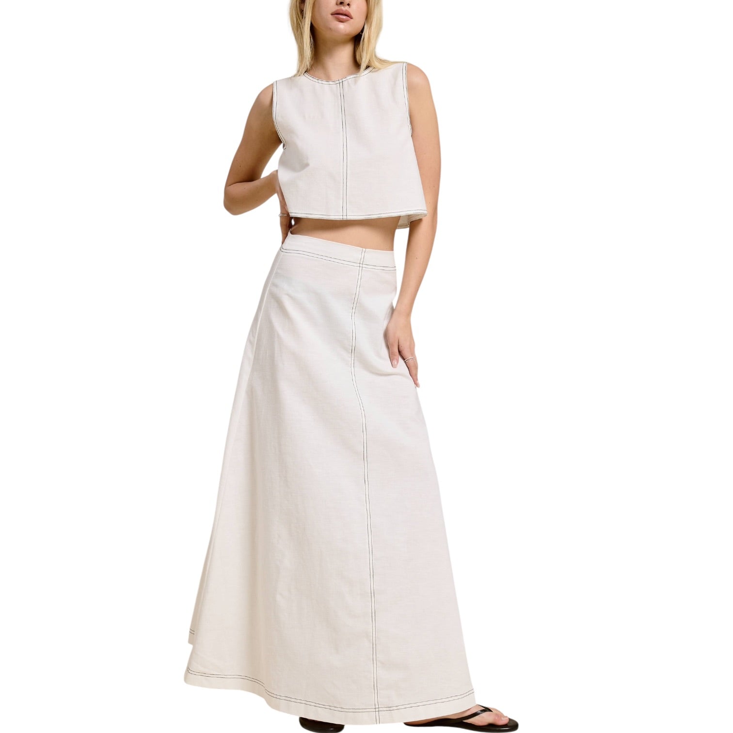 Woman wearing a white sleeveless top and long skirt on a white background