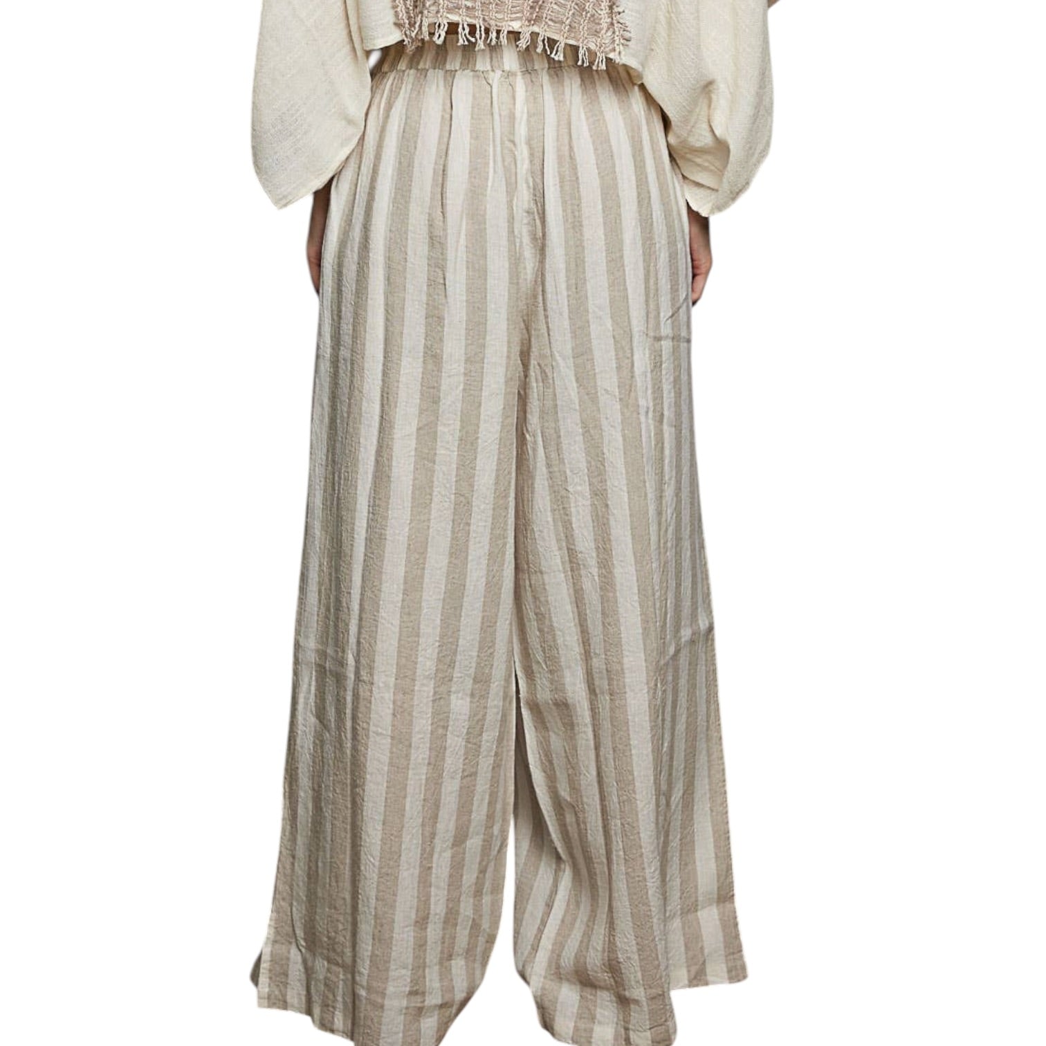 Striped pants worn with a light-colored top on a white background