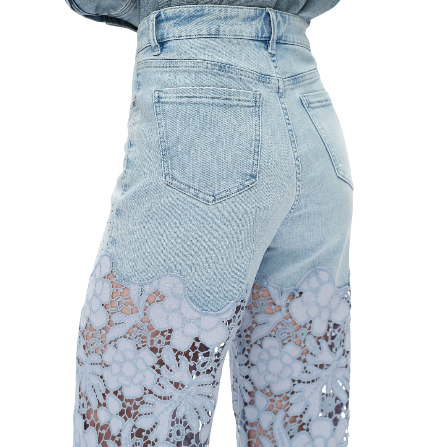Light blue jeans with lace detailing on a white background