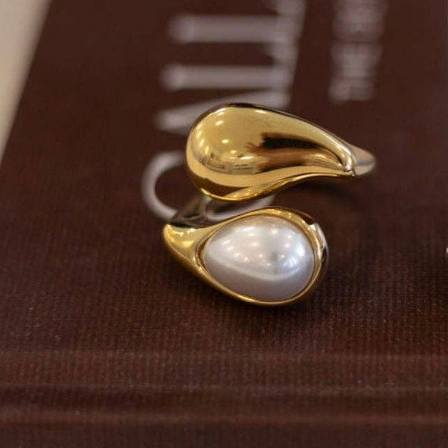 Gold ring with a pearl on a brown textured background