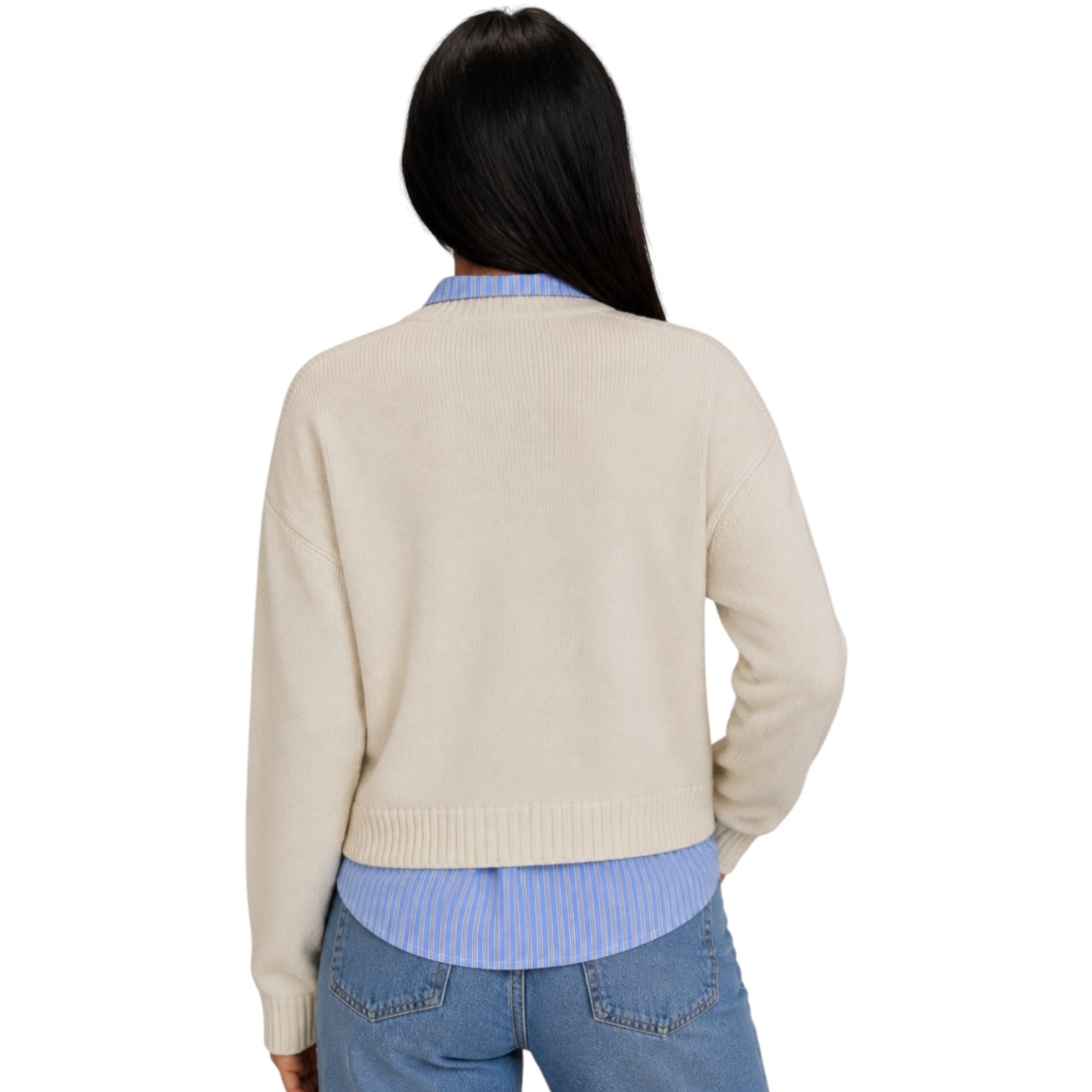 A woman shown from the back wearing a cream-colored ribbed knit cardigan over a light blue striped shirt and blue jeans, against a plain white background.