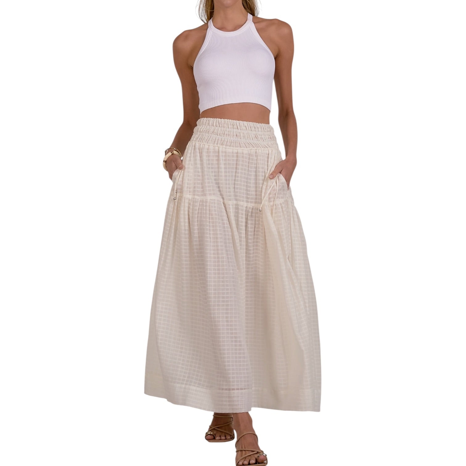 Woman wearing a white top and beige checkered skirt on a white background