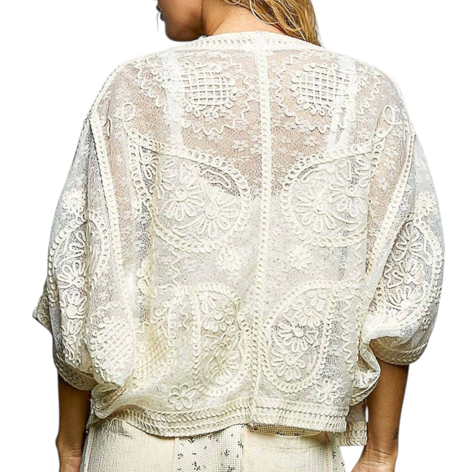 White lace top worn by a person on a white background