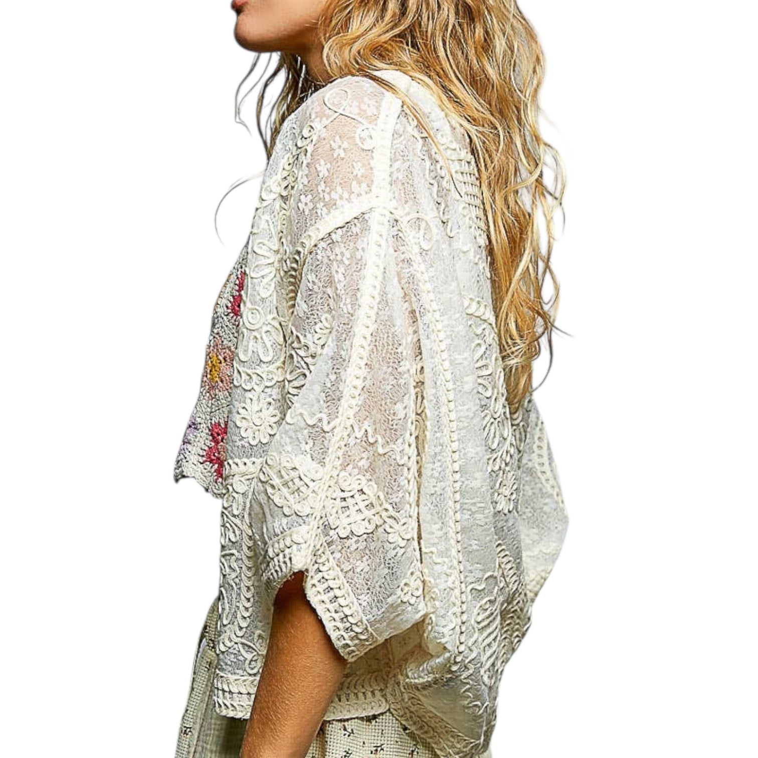 Woman wearing a white lace kimono with floral embroidery on a white background