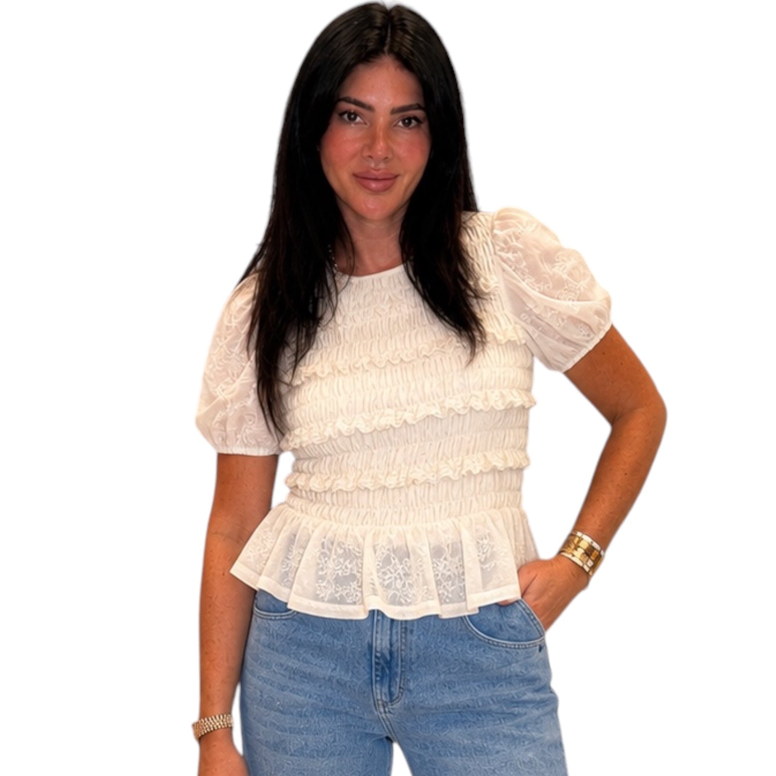 Woman wearing a white lace top and blue jeans on a white background