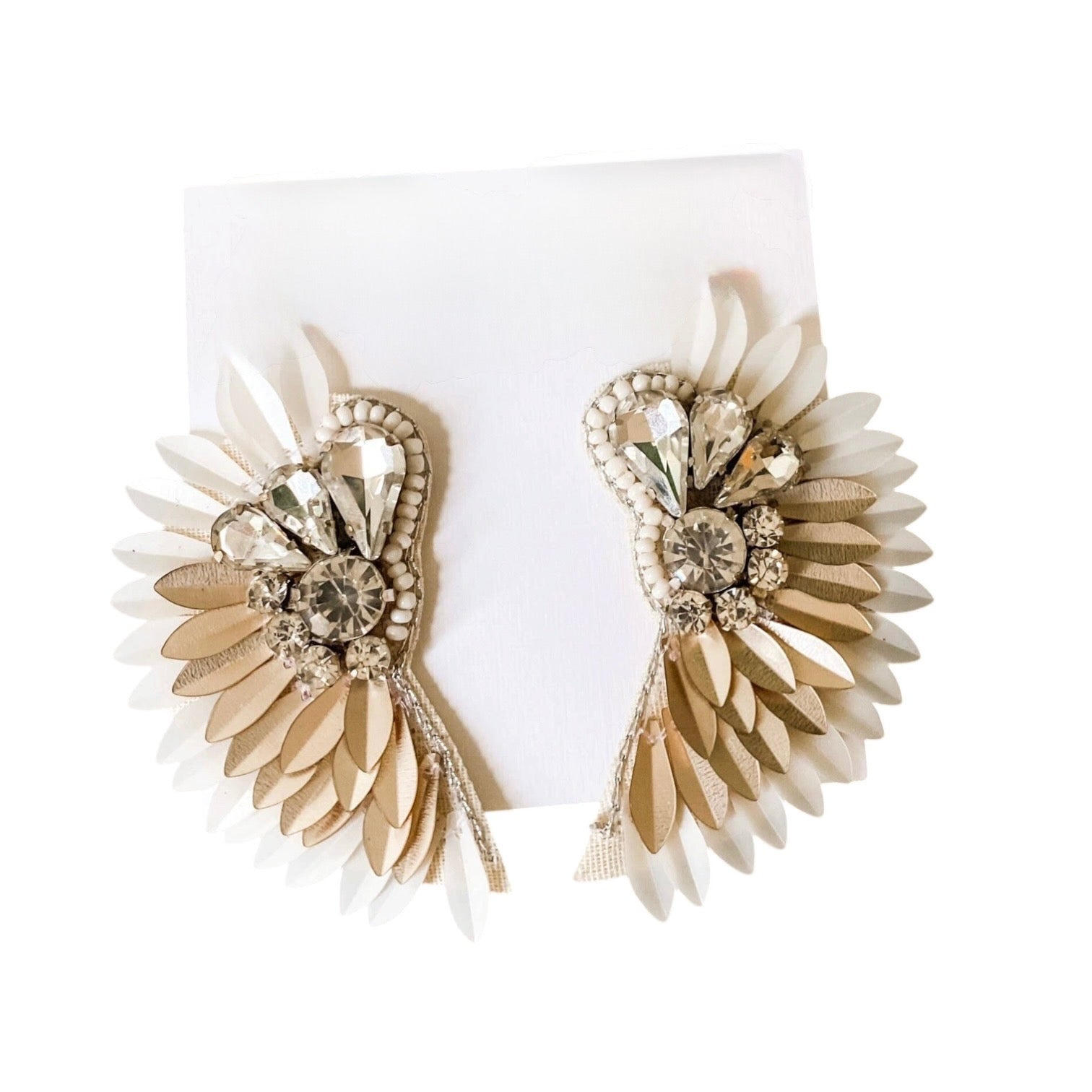 Pair of gold and beige floral earrings on a white background
