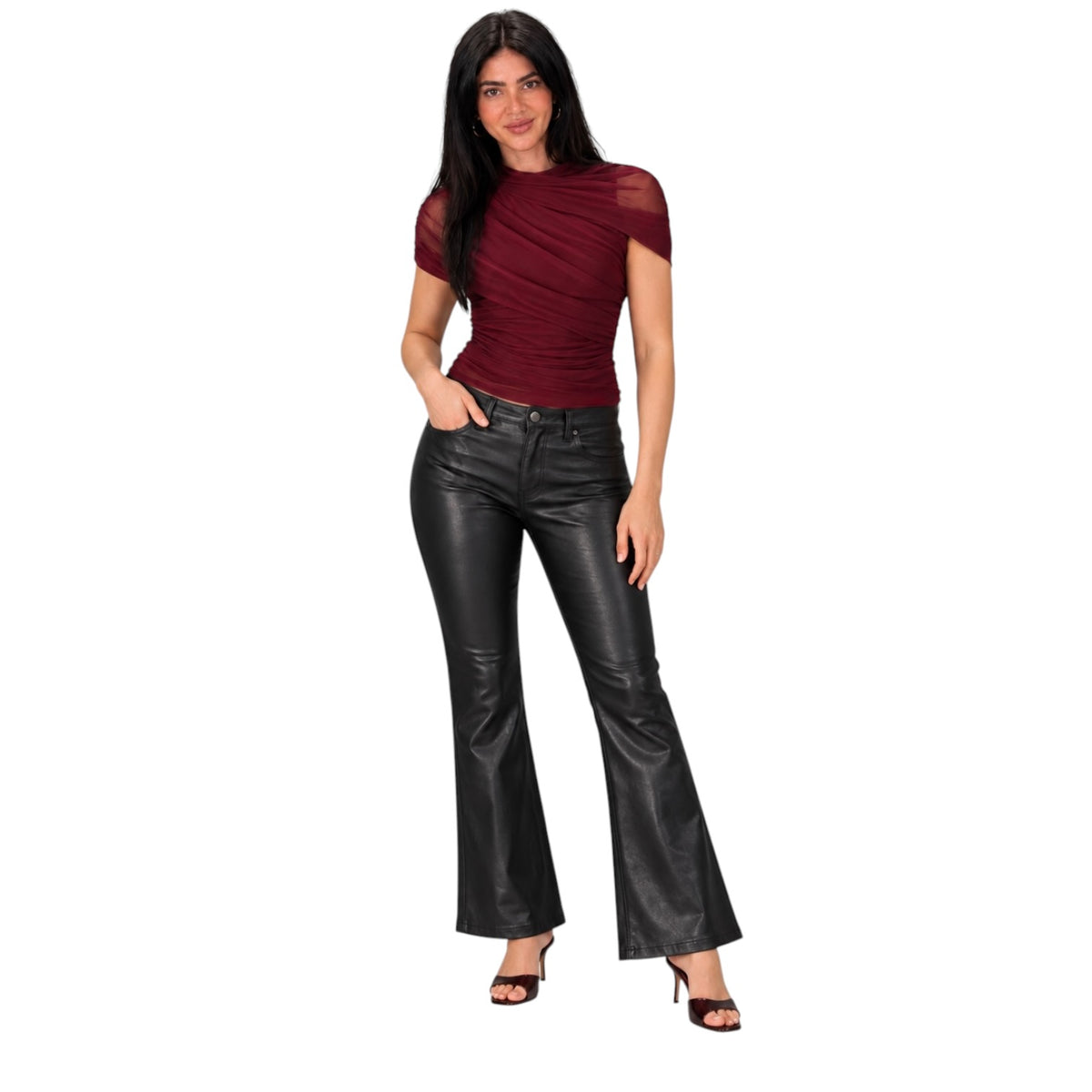 A woman modeling a dark red ruched short-sleeve top and black faux-leather flare pants against a plain white background.
