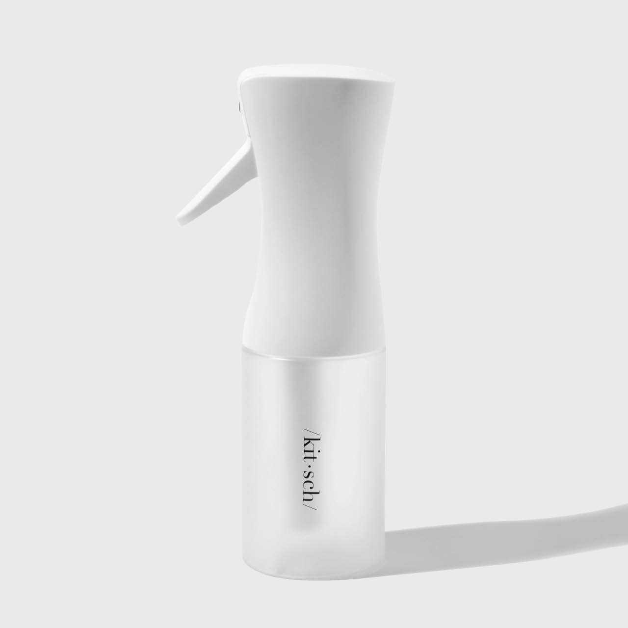 White spray bottle with 'kit-sch' branding on a light gray background