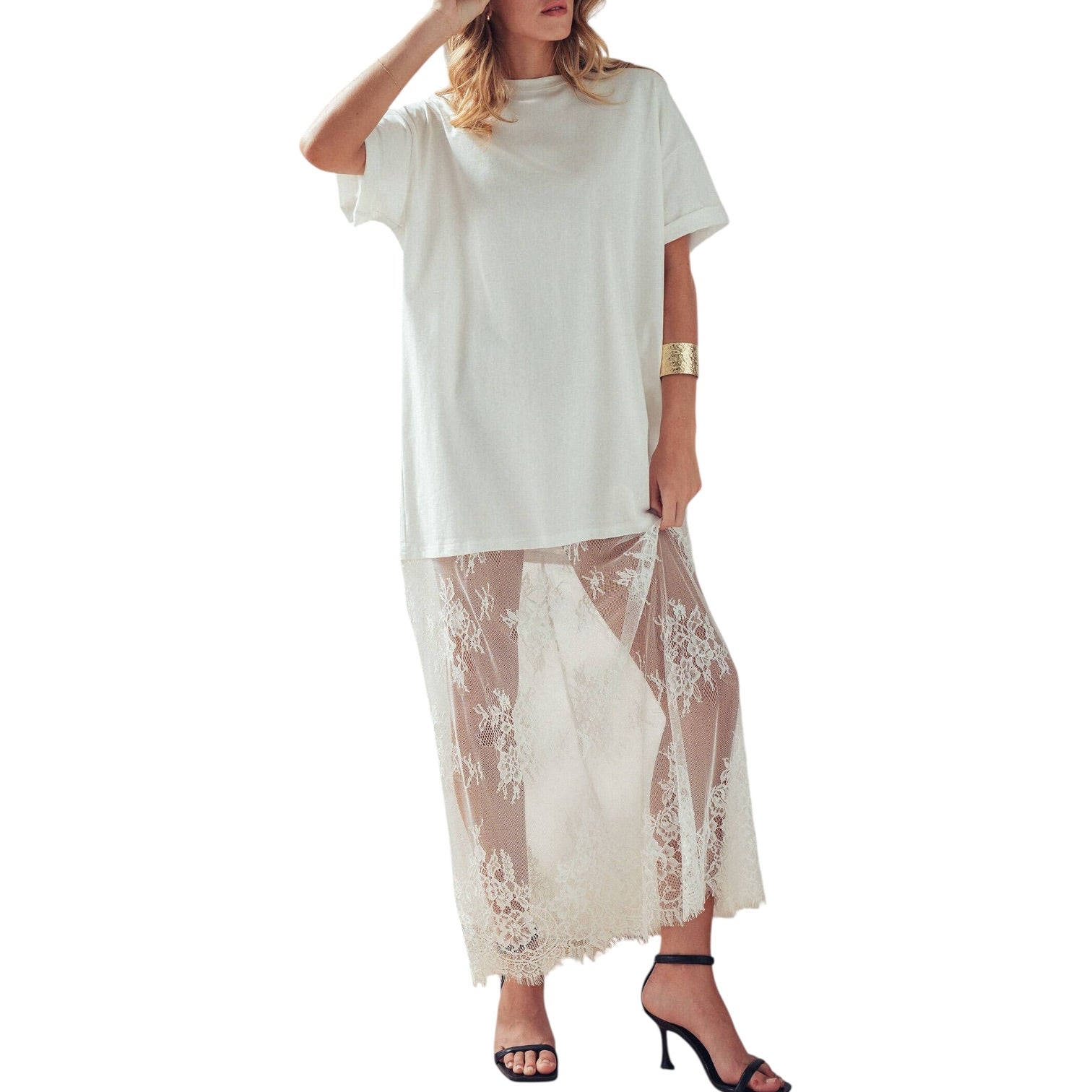 Woman wearing a white dress with a sheer lace overlay on a white background