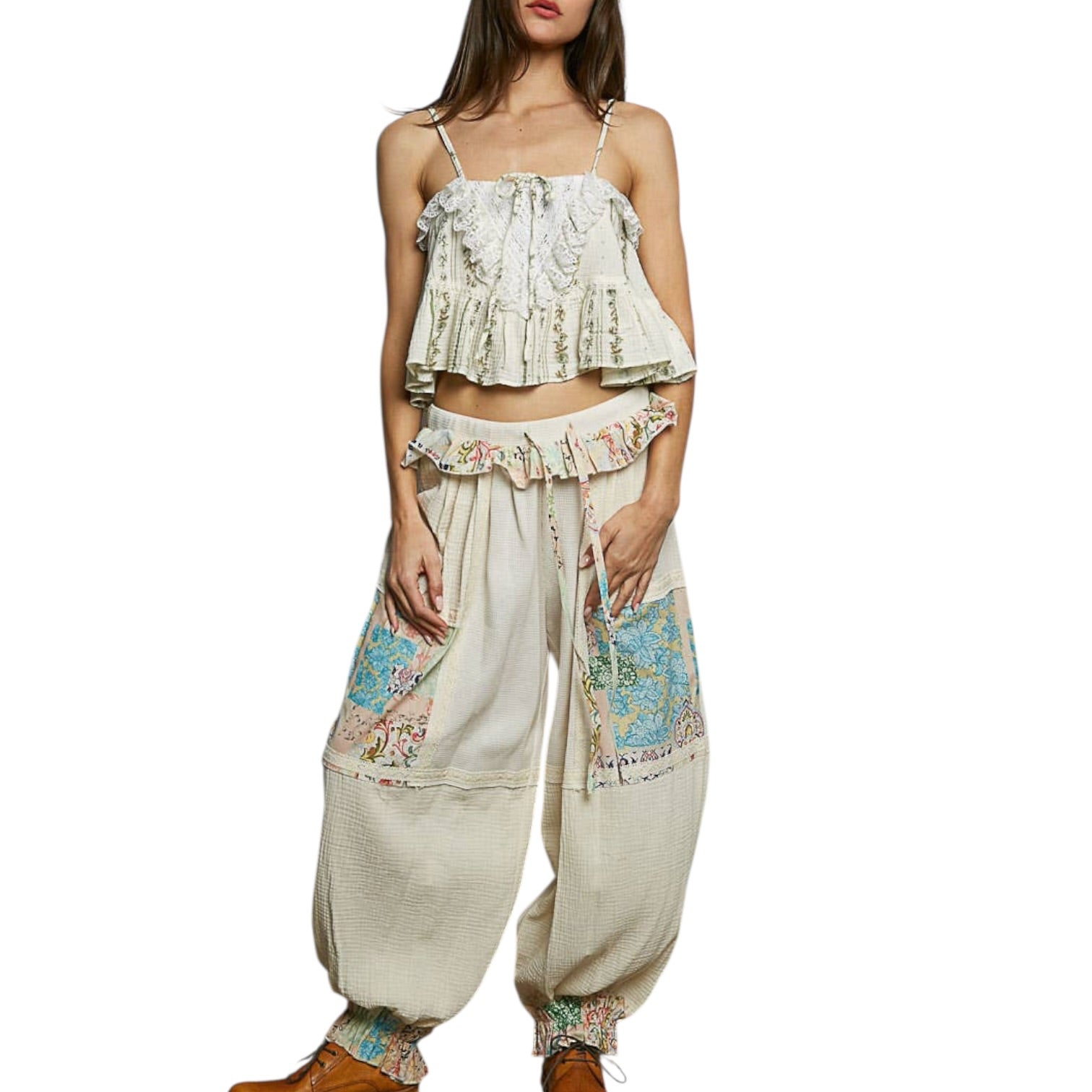 Woman wearing a floral top and wide-leg pants on a white background