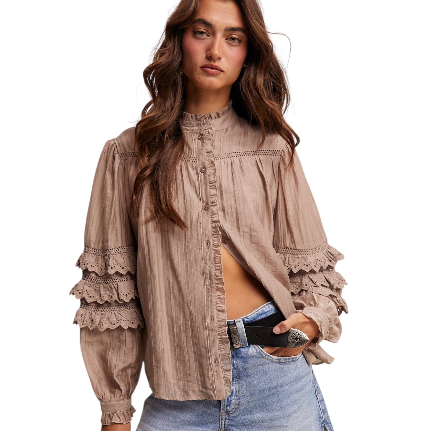 Woman wearing a beige blouse with lace details on a white background