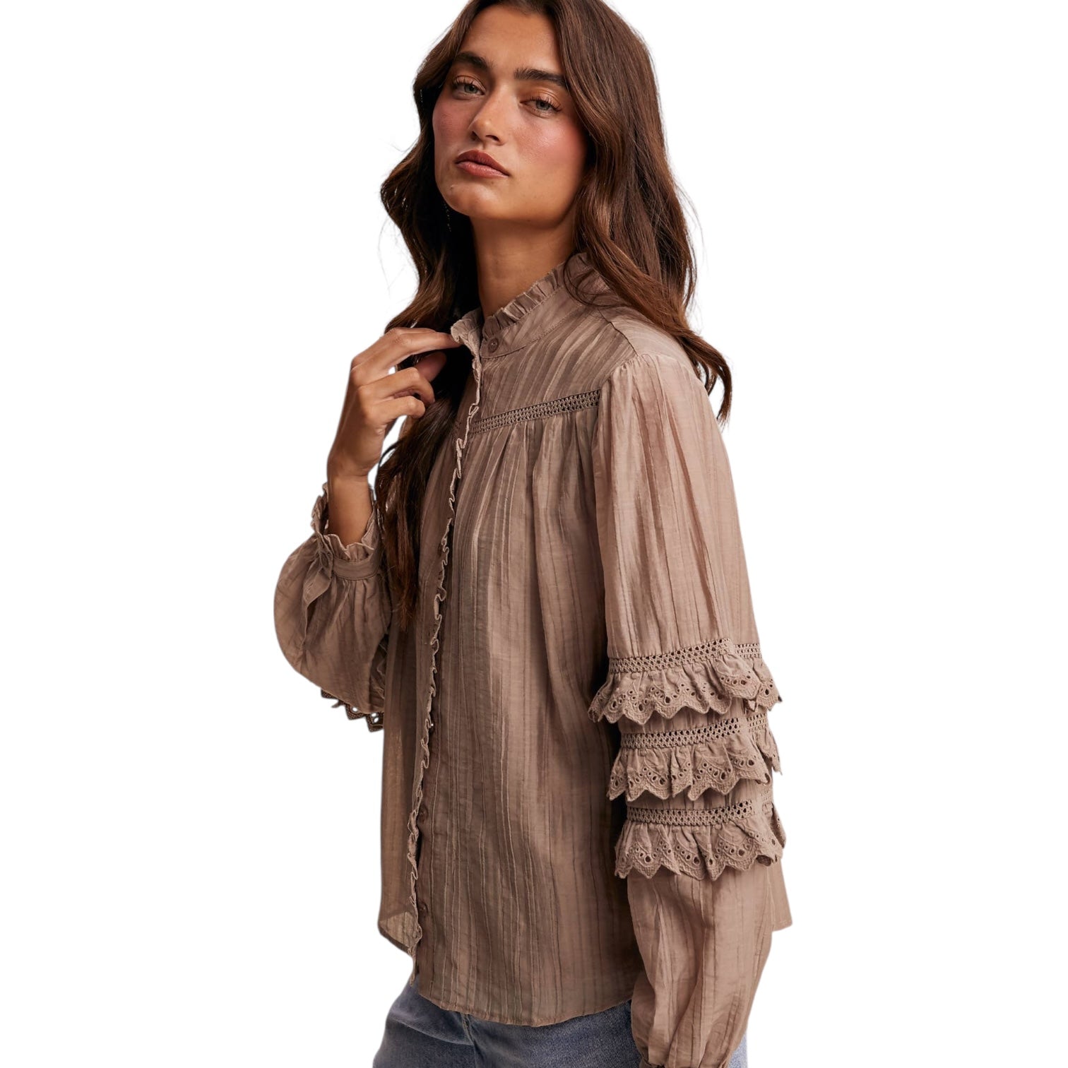 Woman wearing a beige blouse with lace details on a white background