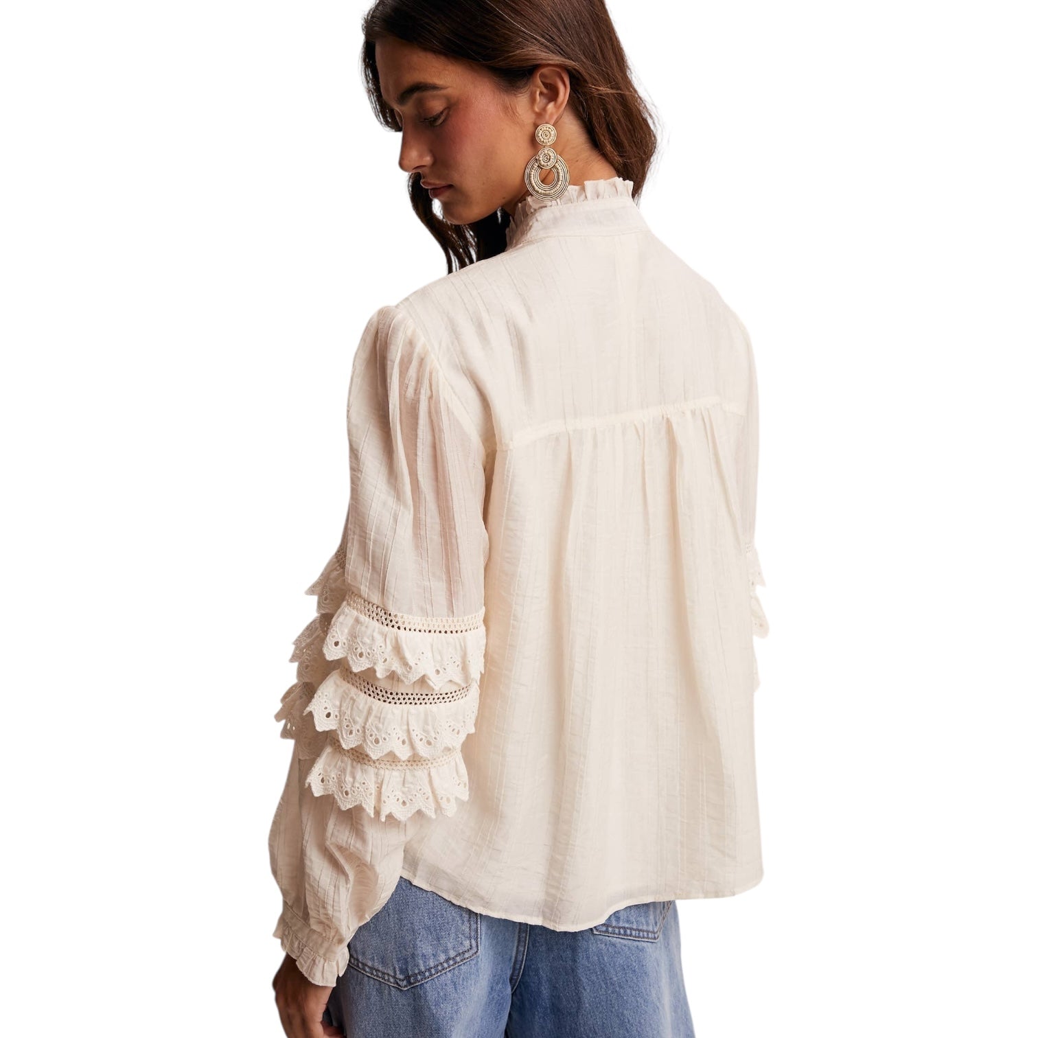 Woman wearing a white blouse with lace details on a white background