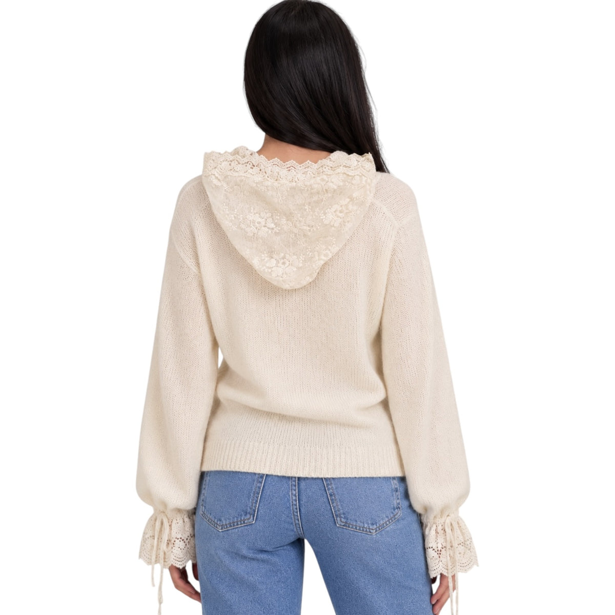 A woman viewed from the back wearing a cream-colored knit hoodie with a lace-trimmed hood and lace-up cuffs, paired with blue jeans, against a plain white background.