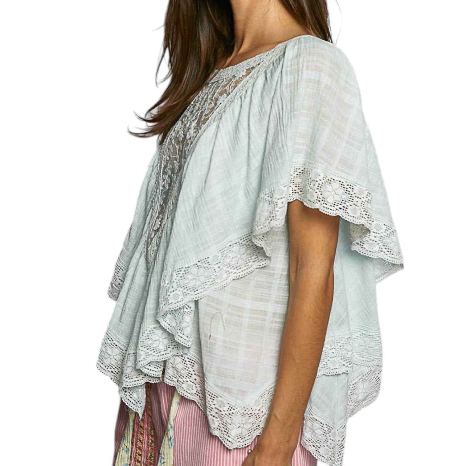 Light blue lace top worn by a person on a white background