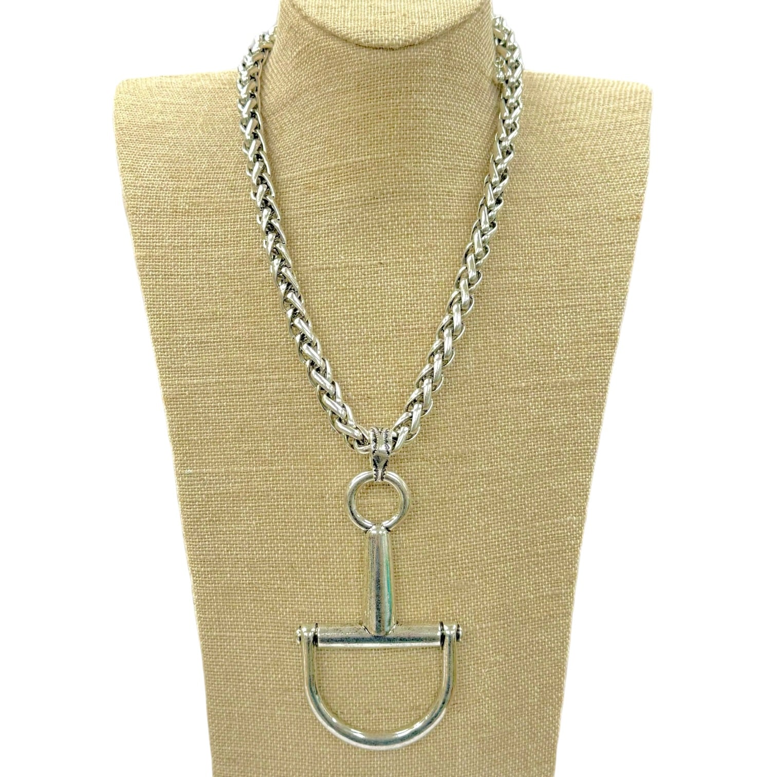 A silver horse bit chain necklace displayed on a beige fabric mannequin bust against a white background.