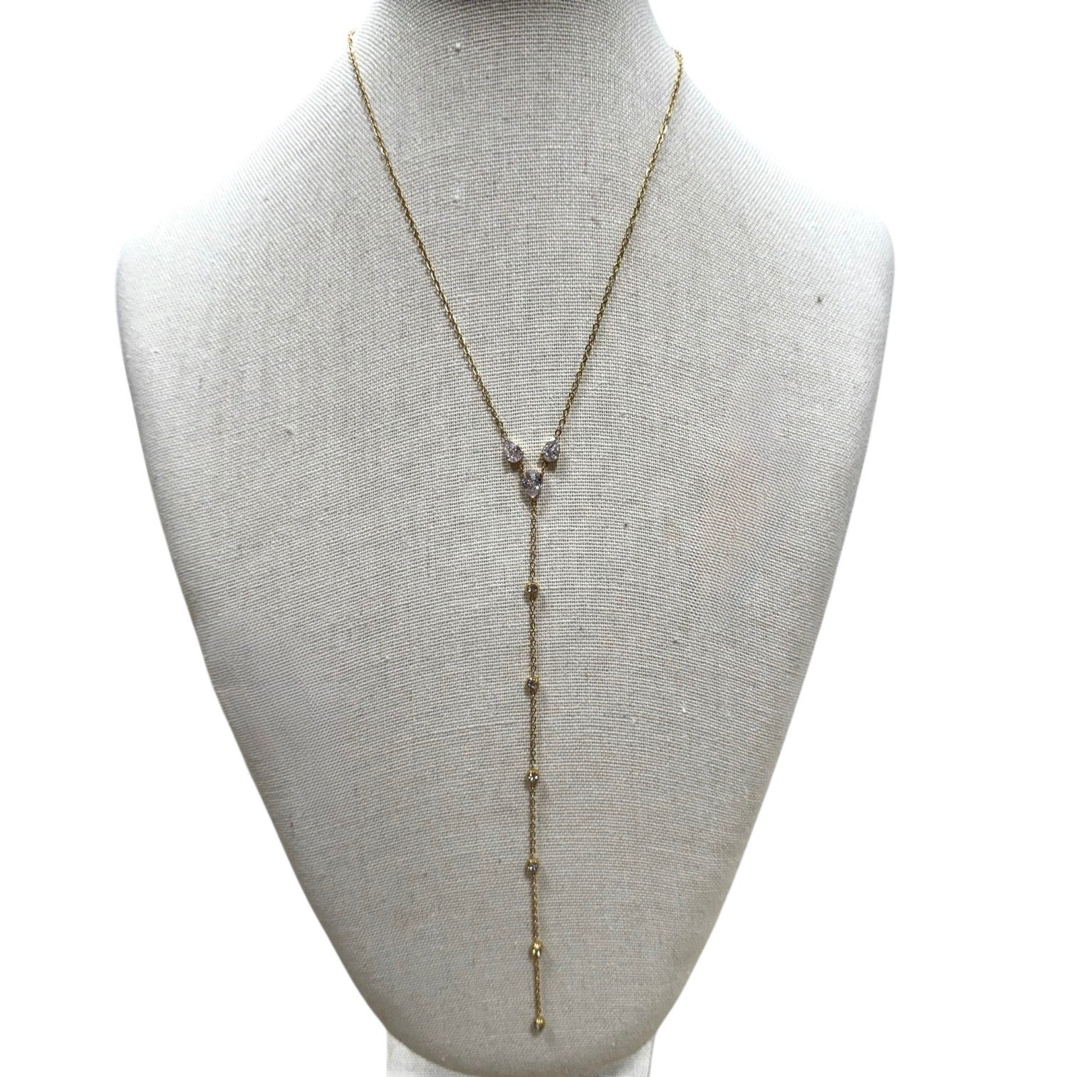 Gold necklace with beads on a mannequin bust against a white background
