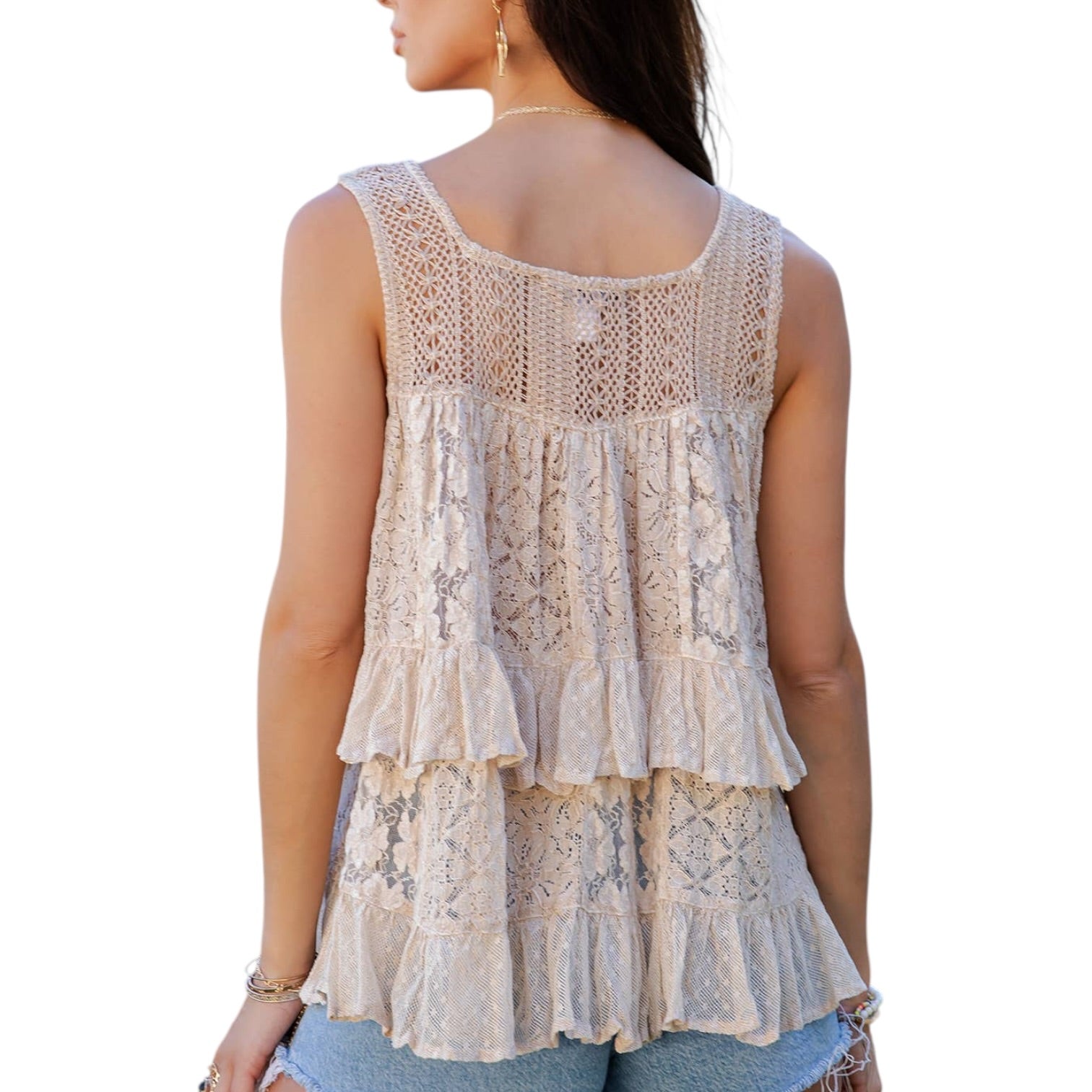 Woman wearing a beige lace sleeveless top on a white background