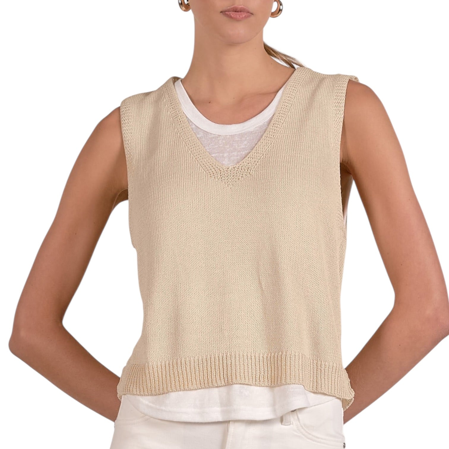 Beige knitted vest over a white shirt and pants on a white background