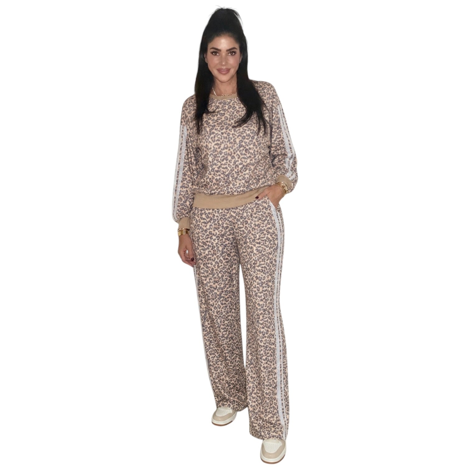 A woman modeling a matching two-piece tracksuit with a beige and brown leopard print pattern, featuring a long-sleeve top with white side stripes and matching wide-leg pants.
