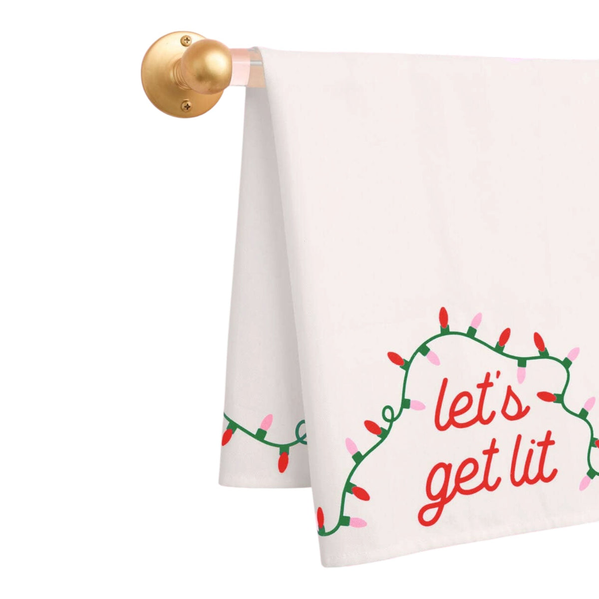 A white kitchen towel hanging from a gold wall-mounted rod, printed with a green Christmas light garland and the phrase 'let's get lit' in red script.