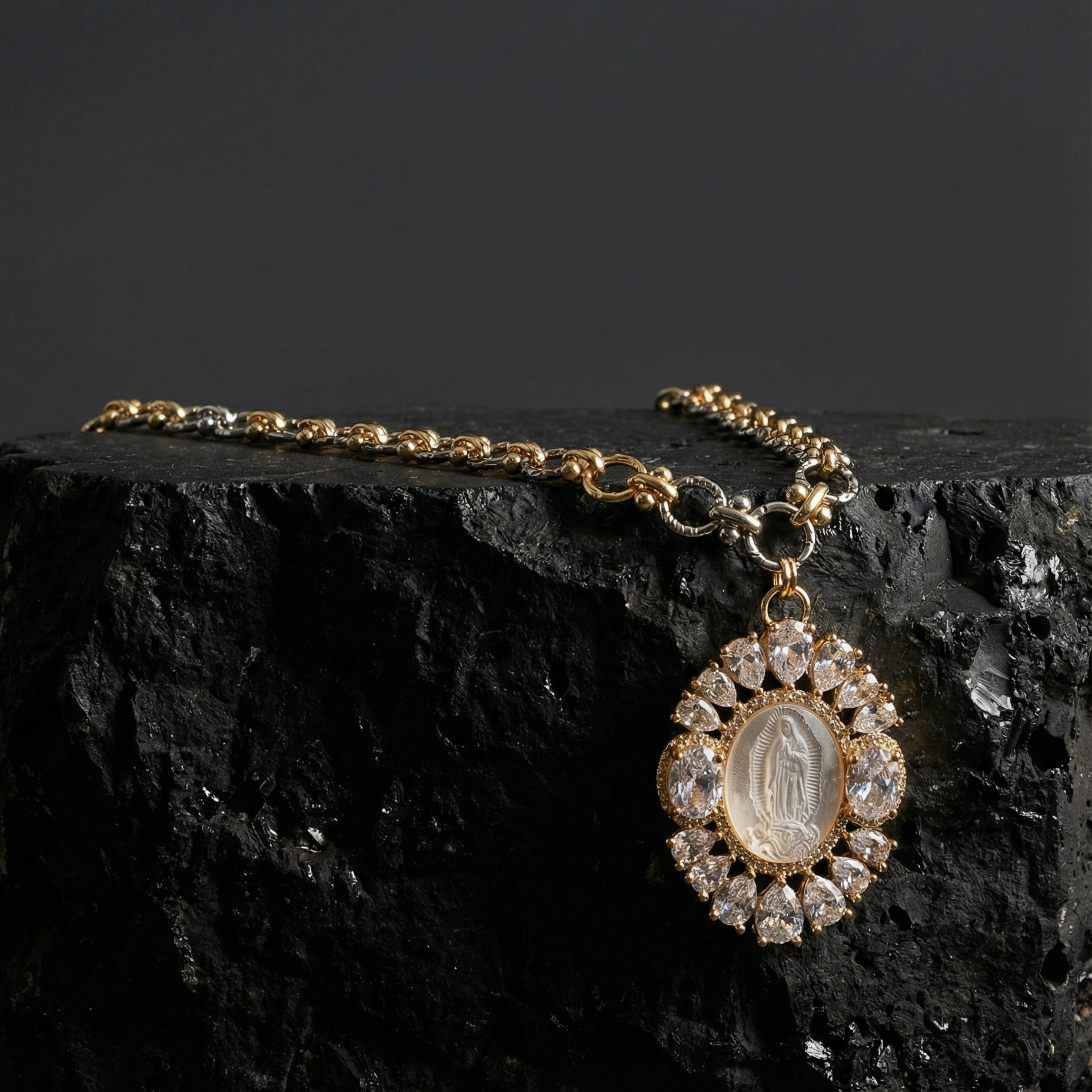 Gold necklace with a pendant on a dark stone surface