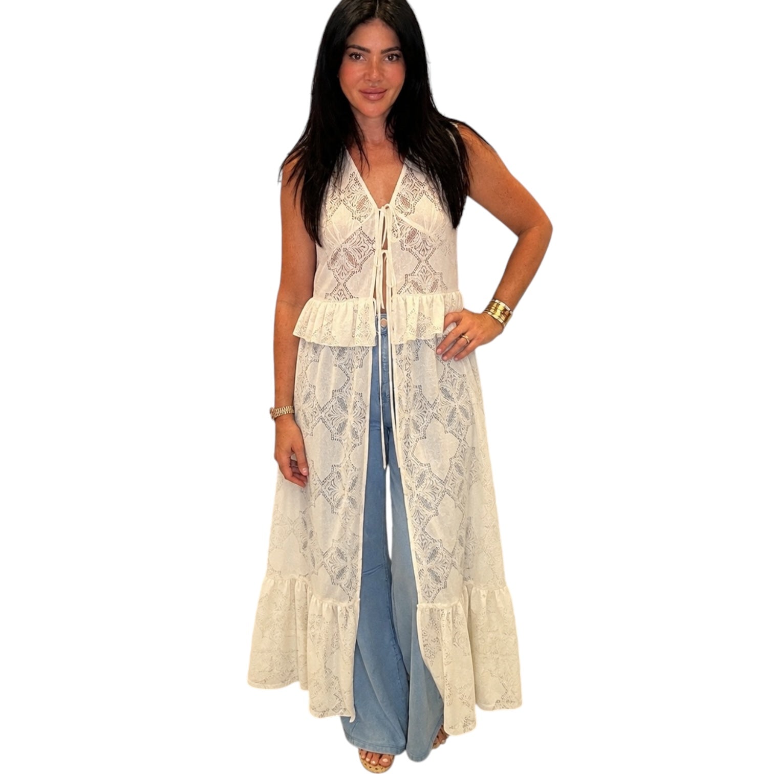 Woman wearing a long beige top over denim on a white background