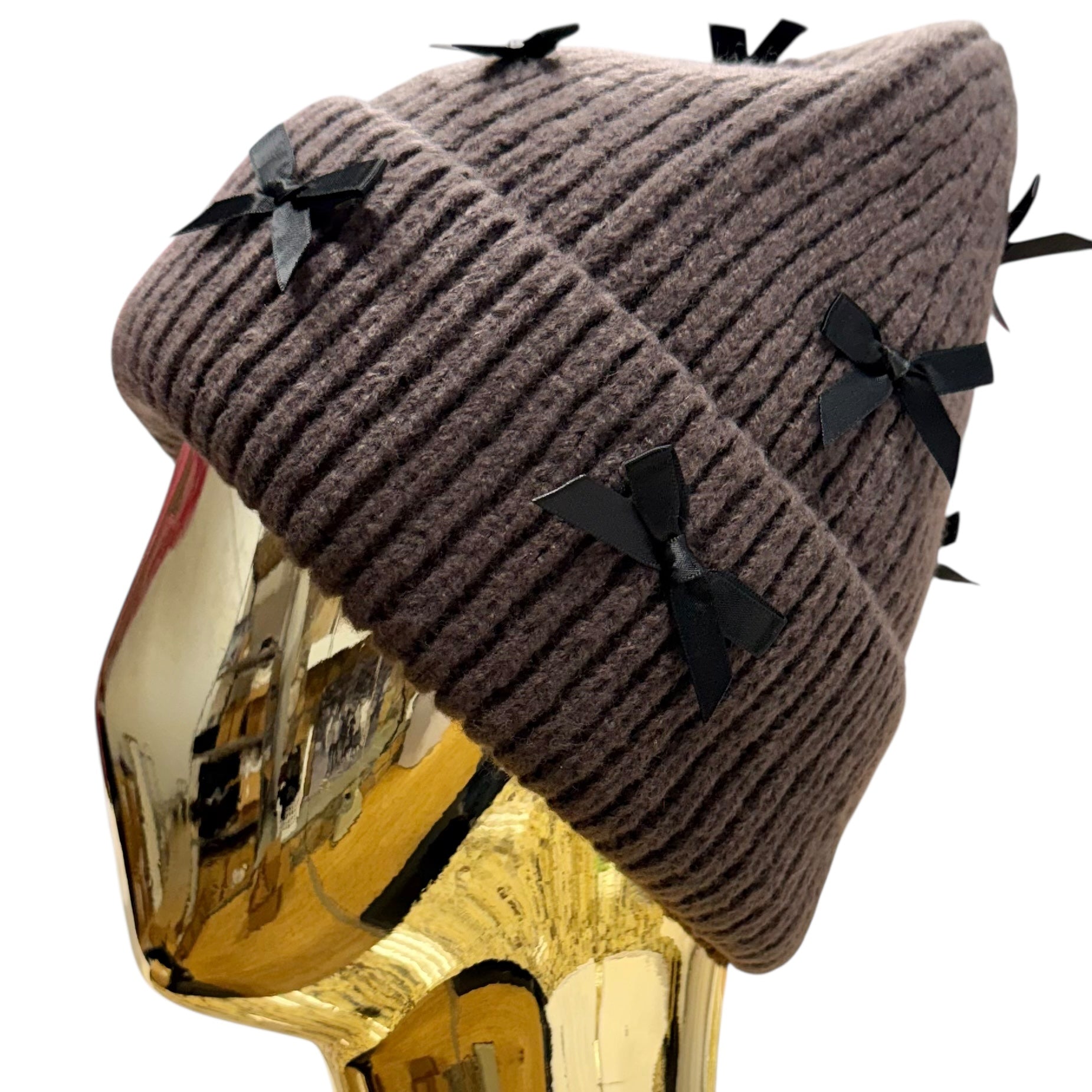 Brown knit beanie with black bows on a white background