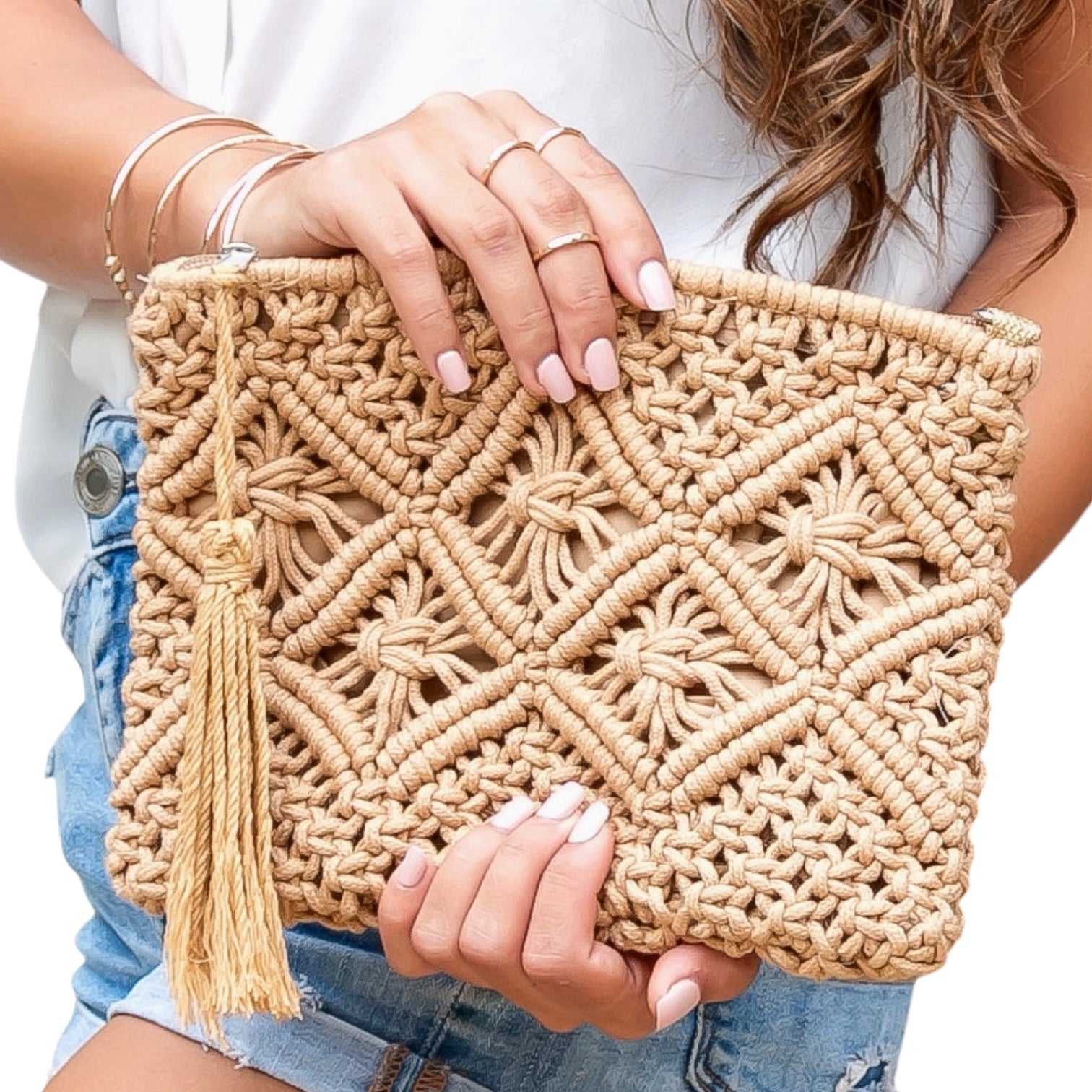 Woven clutch held by a person with a white background