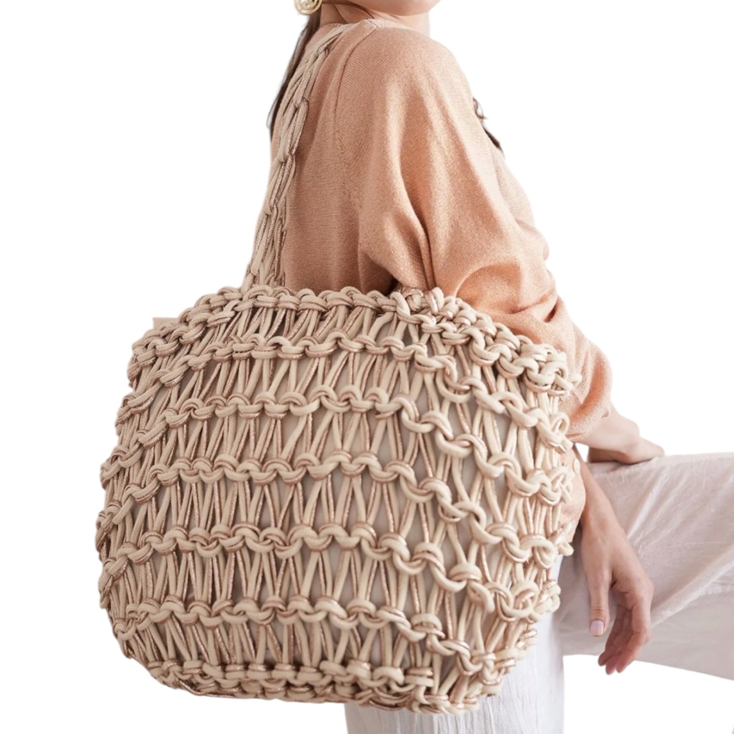 Beige woven handbag held by a person wearing a beige sweater on a white background