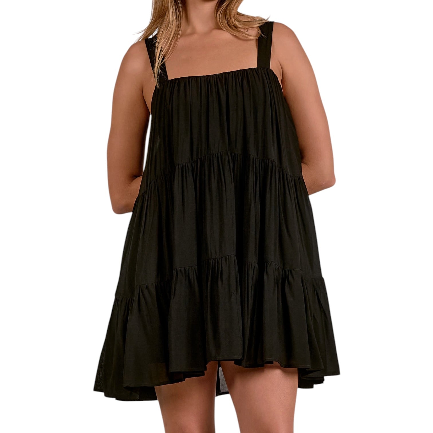 Black tiered dress worn by a person on a white background