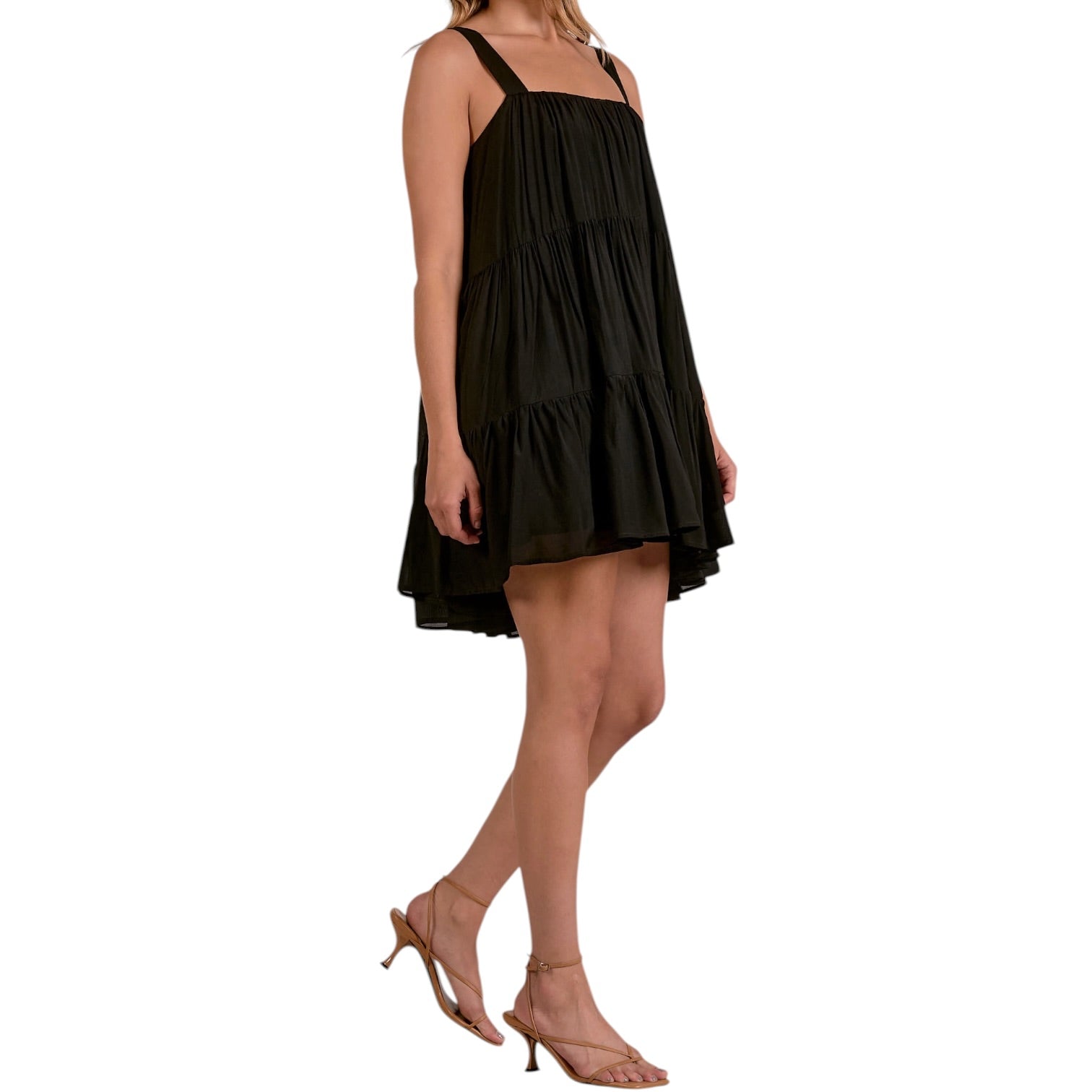 Black tiered dress worn by a model on a white background