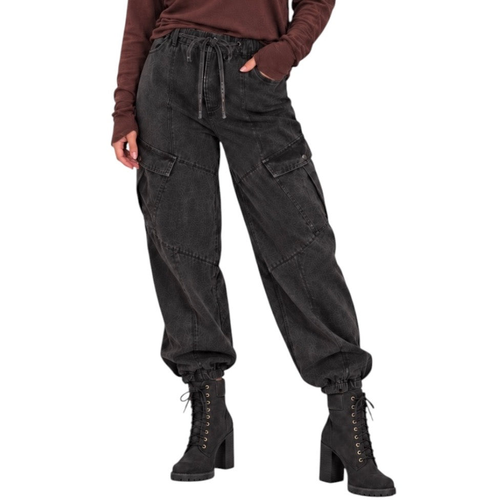 A person wearing dark charcoal cargo jogger pants with an elastic drawstring waist, side cargo pockets, and elastic cuffs, paired with black lace-up ankle boots against a plain white background.