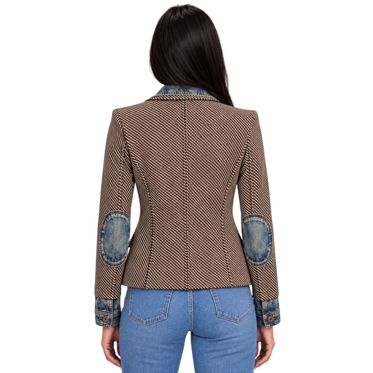 A woman viewed from the back wearing a brown and black diagonally striped blazer with blue denim elbow patches and a blue denim collar, paired with blue jeans against a white background.