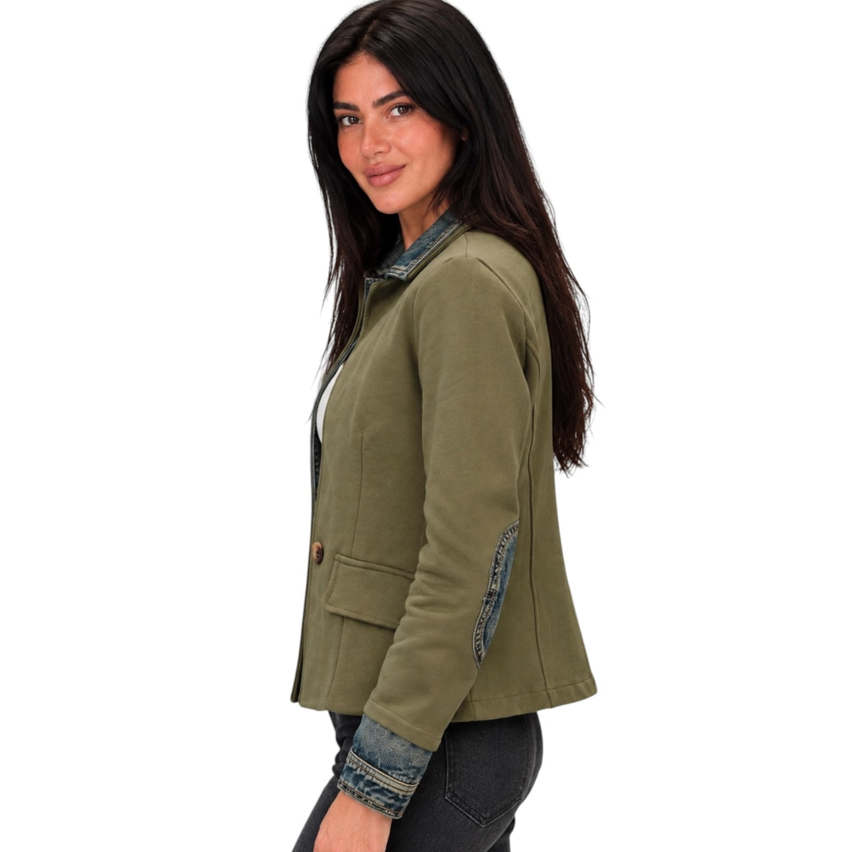 A woman wearing an olive green cropped jacket with denim trim details, paired with dark jeans, shown from a side profile against a plain white background.