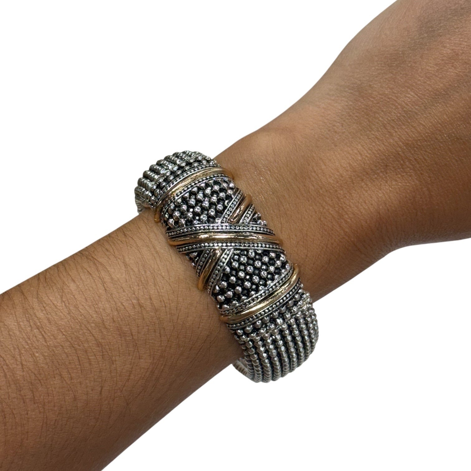 A wide silver-toned cuff bracelet with textured bead rows and gold-toned accent bands, shown worn on a person's wrist against a plain white background.