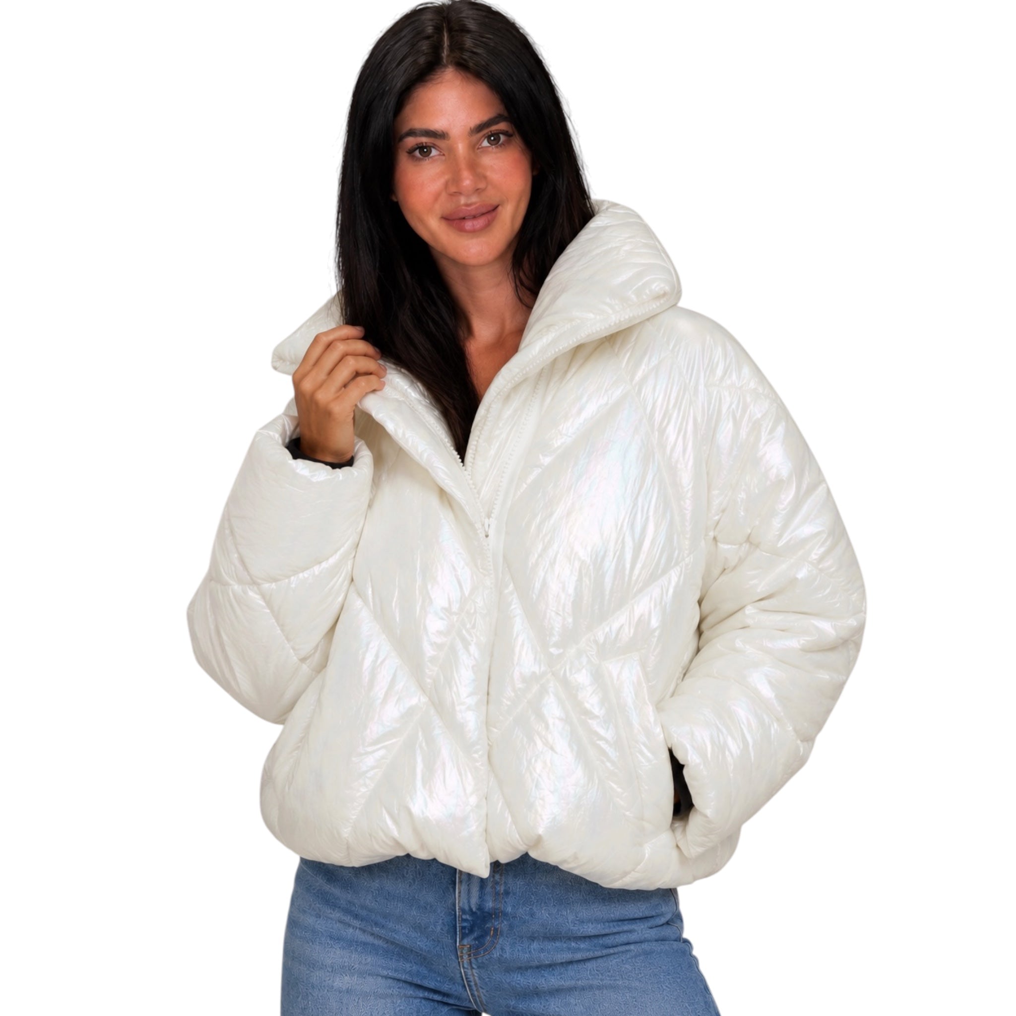 A woman wearing a shiny, puffy white quilted puffer jacket with a high collar, paired with blue jeans, set against a plain white background.