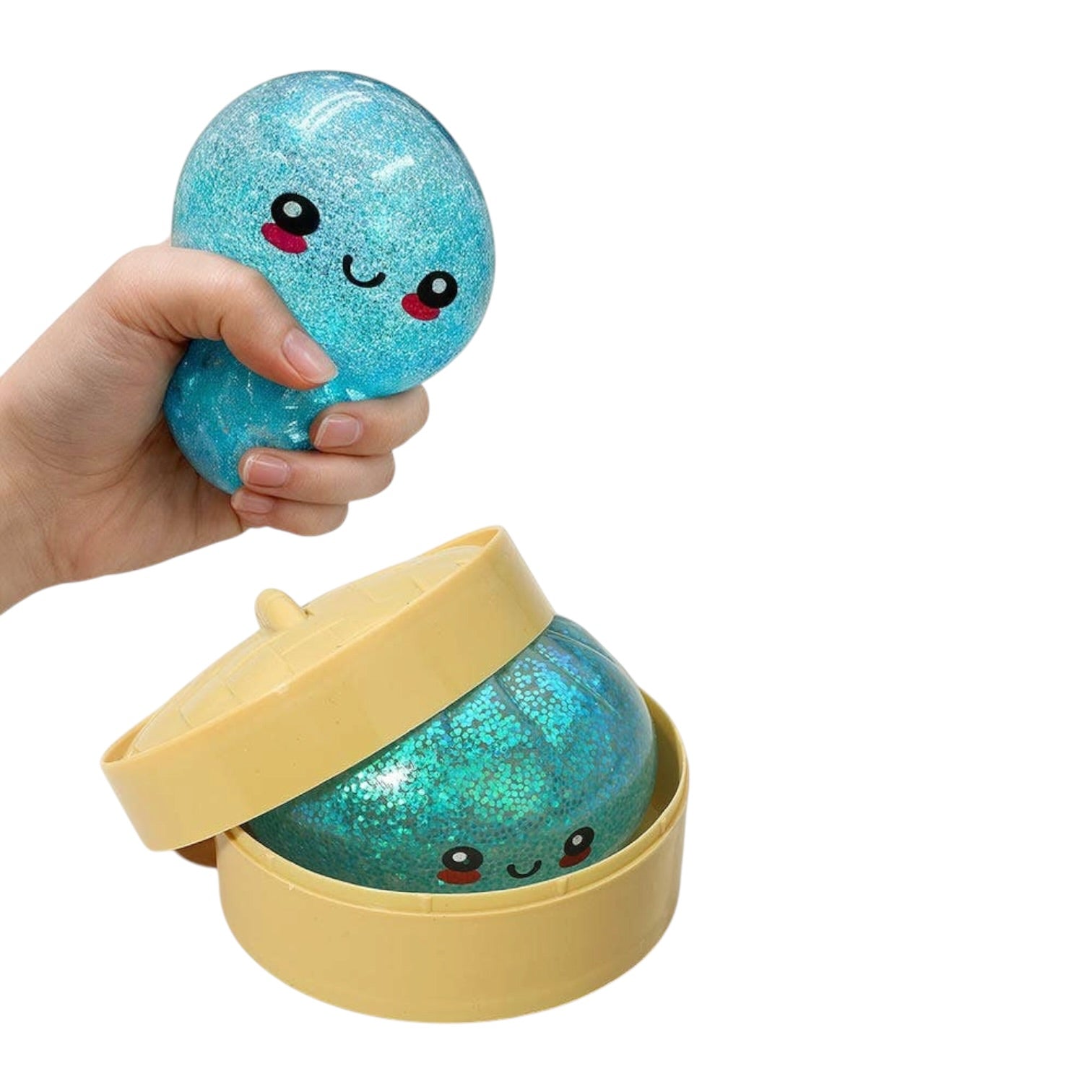 Hand holding a blue glittery ball with a smiley face, inside a yellow container on a white background