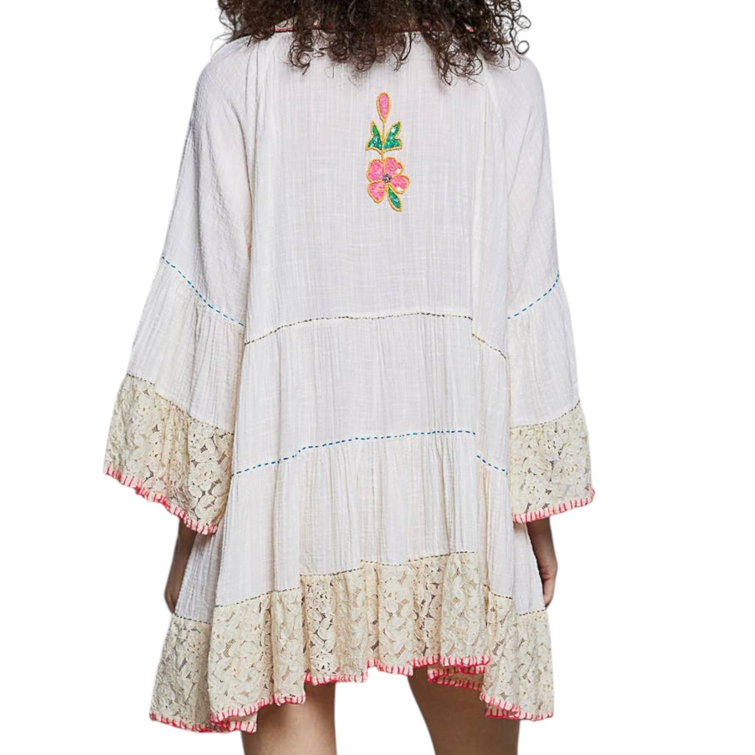 White dress with floral embroidery and lace details on a white background