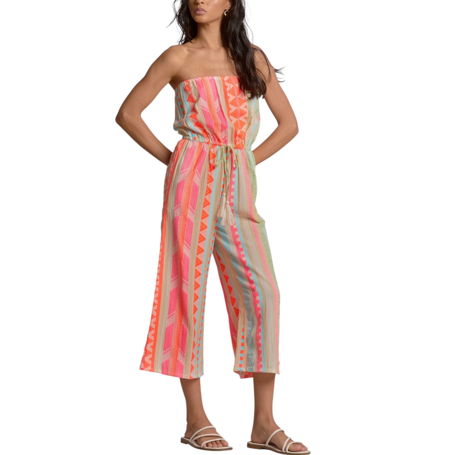 Woman wearing a colorful strapless jumpsuit on a white background